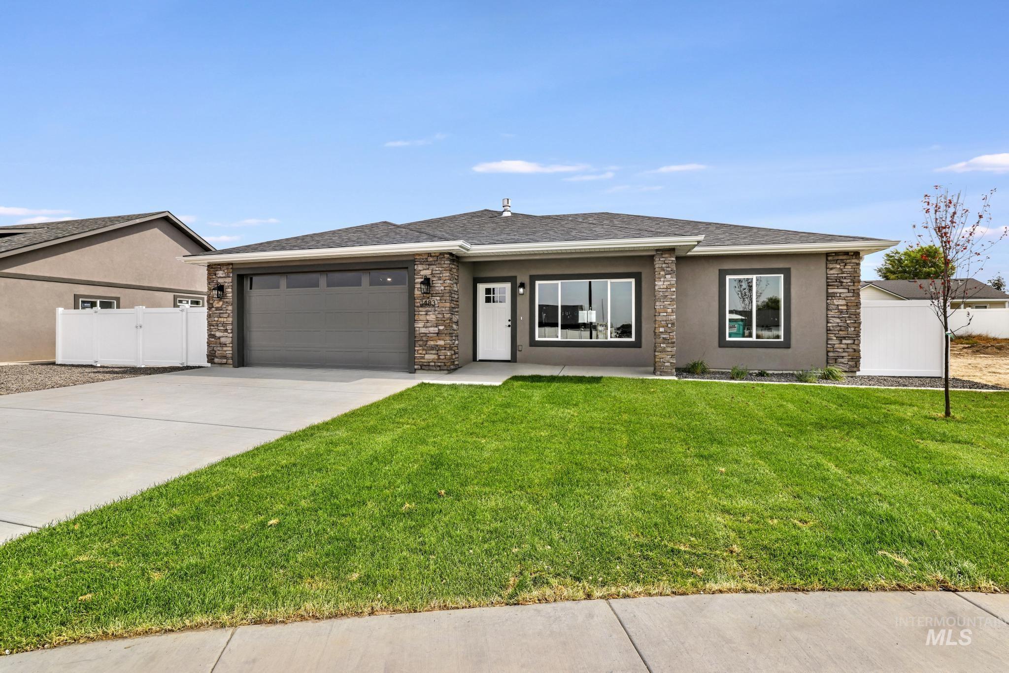 Prairie-style home with stucco siding, driveway, an attached garage, stone siding, and a shingled roof