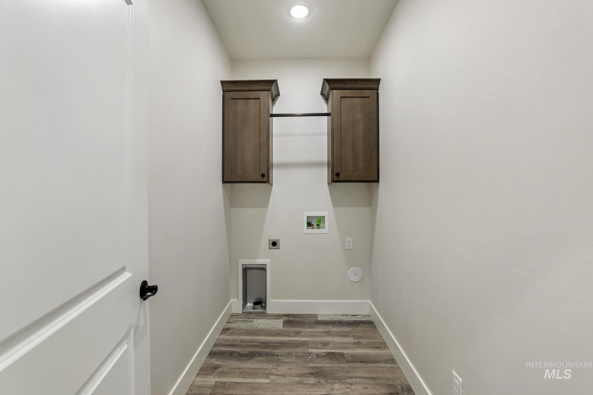 Laundry room featuring cabinet space, electric dryer hookup, light wood-style flooring, and hookup for a washing machine
