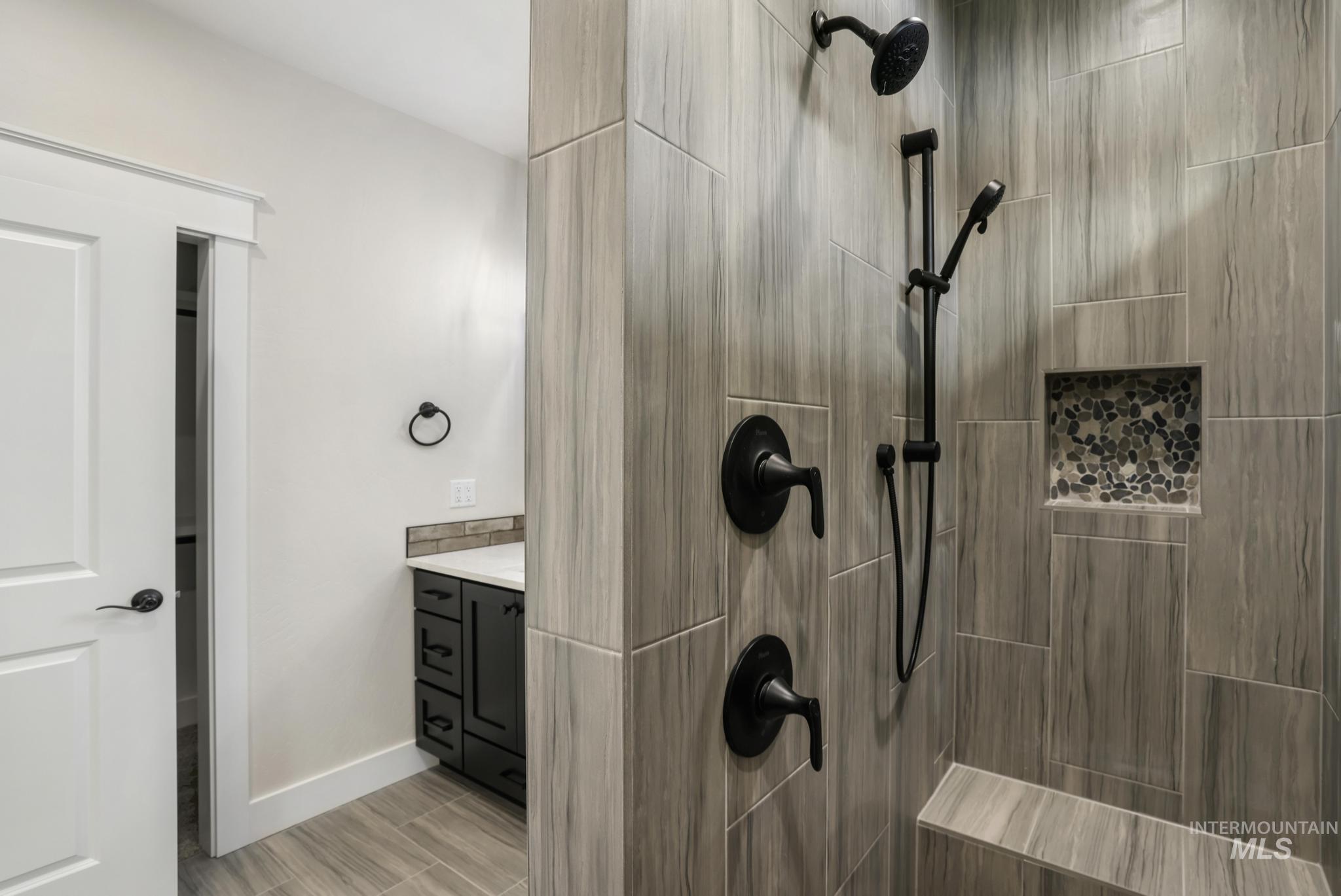Full bath featuring vanity and a tile shower