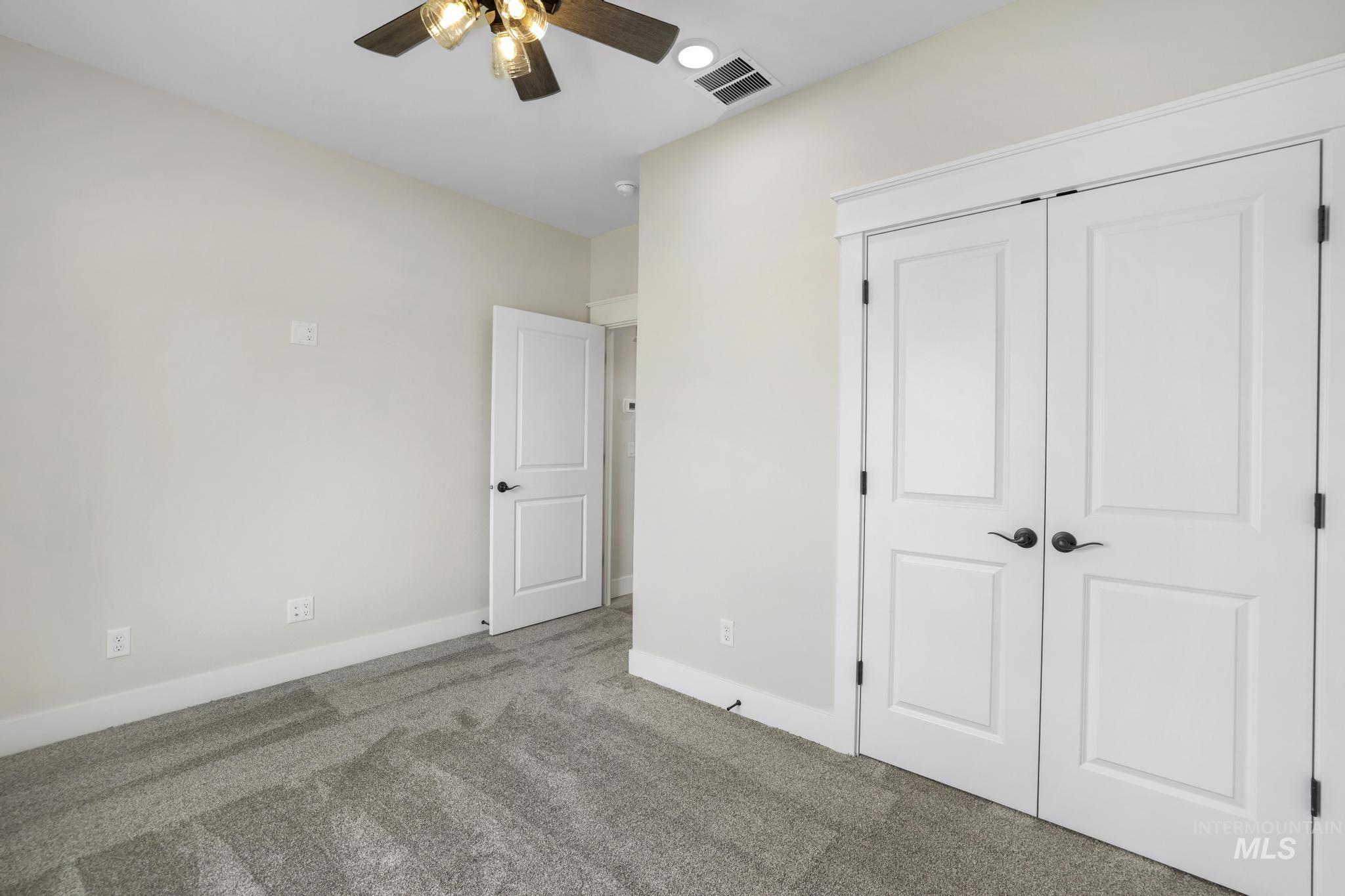 Unfurnished bedroom featuring carpet, a closet, and ceiling fan