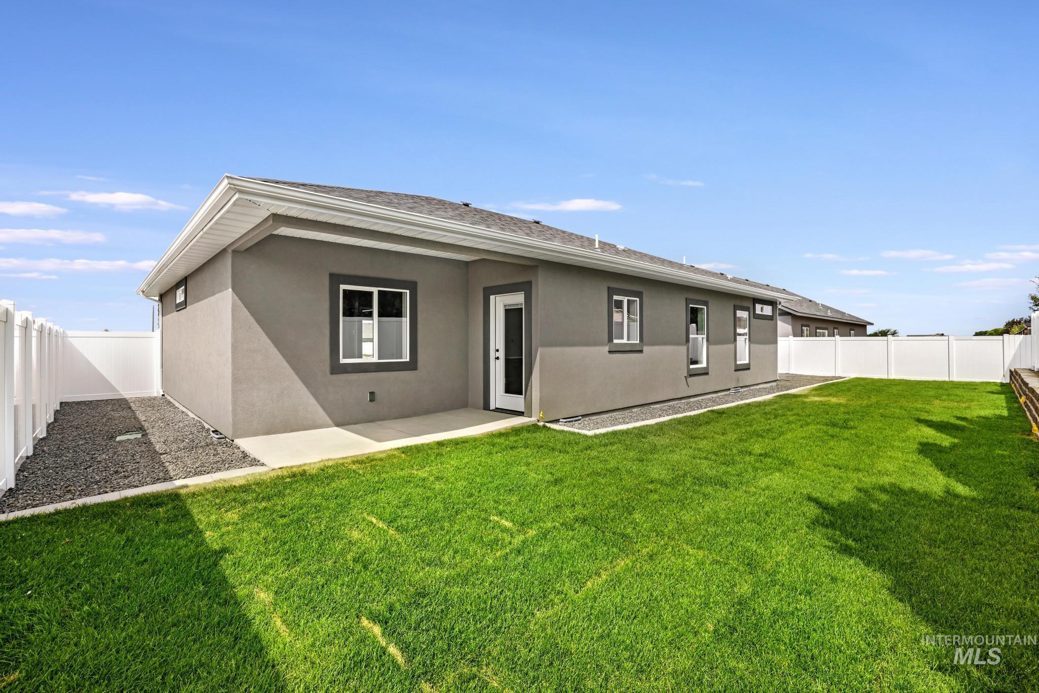 Rear view of property featuring a fenced backyard, stucco siding, and a patio