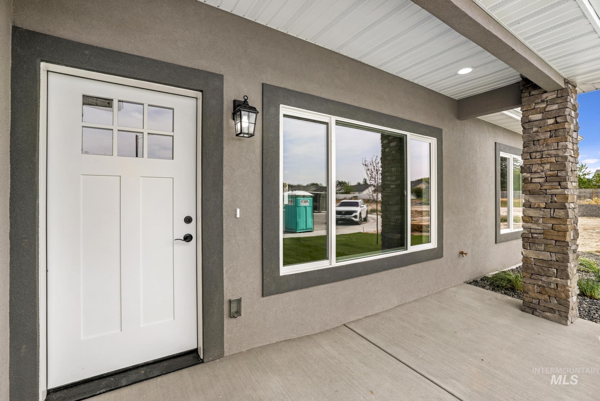 Doorway to property with stucco siding and a patio