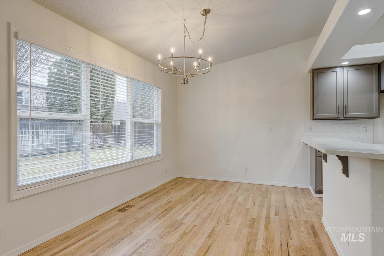 Unfurnished dining area with light wood-style floors and a chandelier