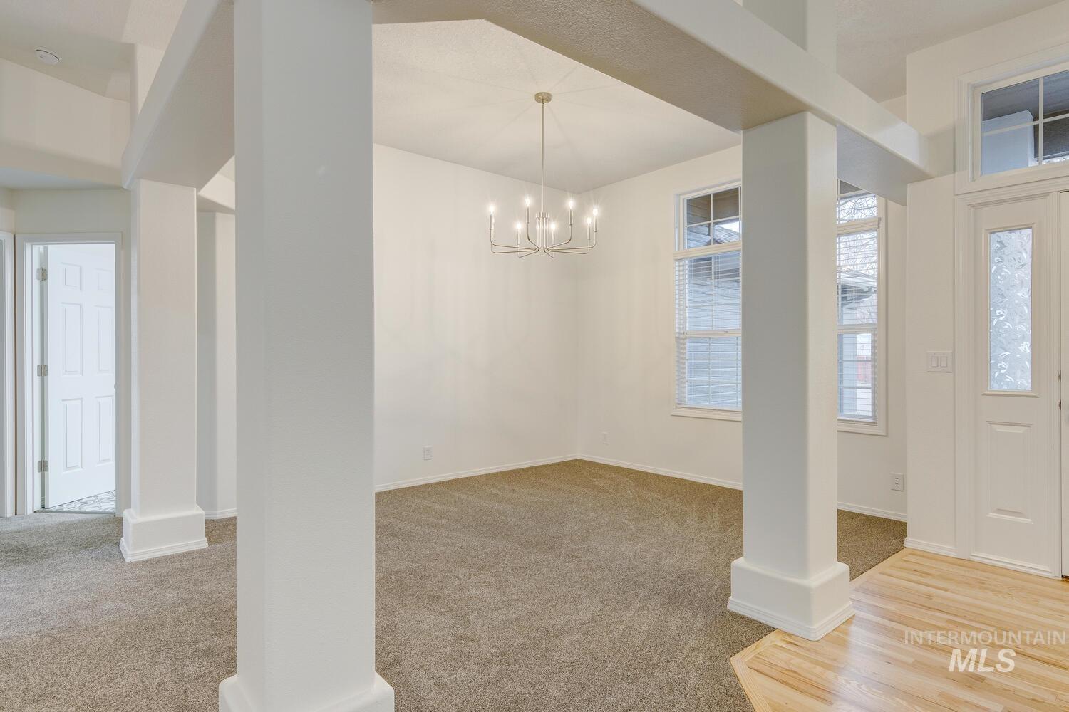 Foyer with light carpet and a chandelier