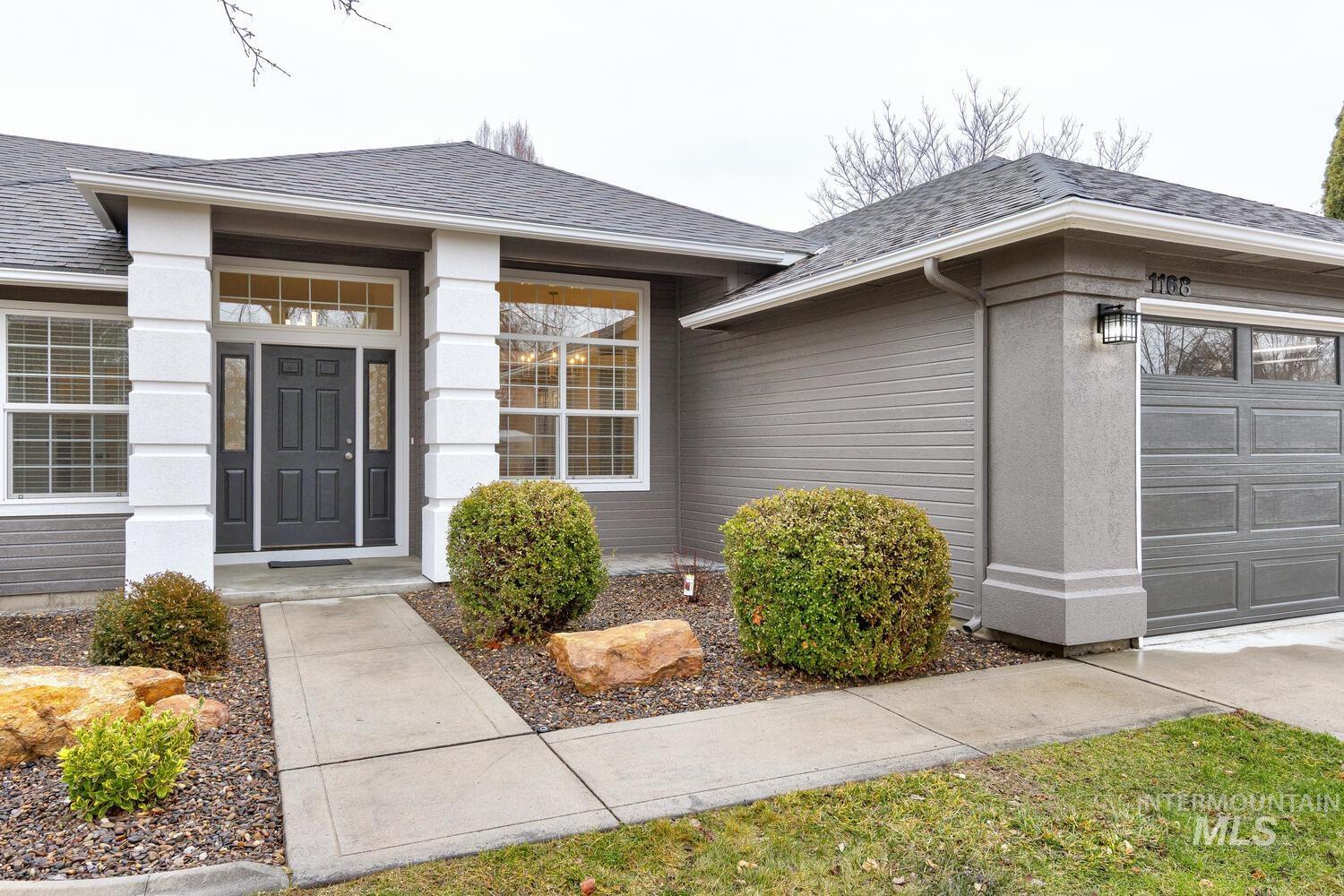 Entrance to property with a shingled roof and a garage