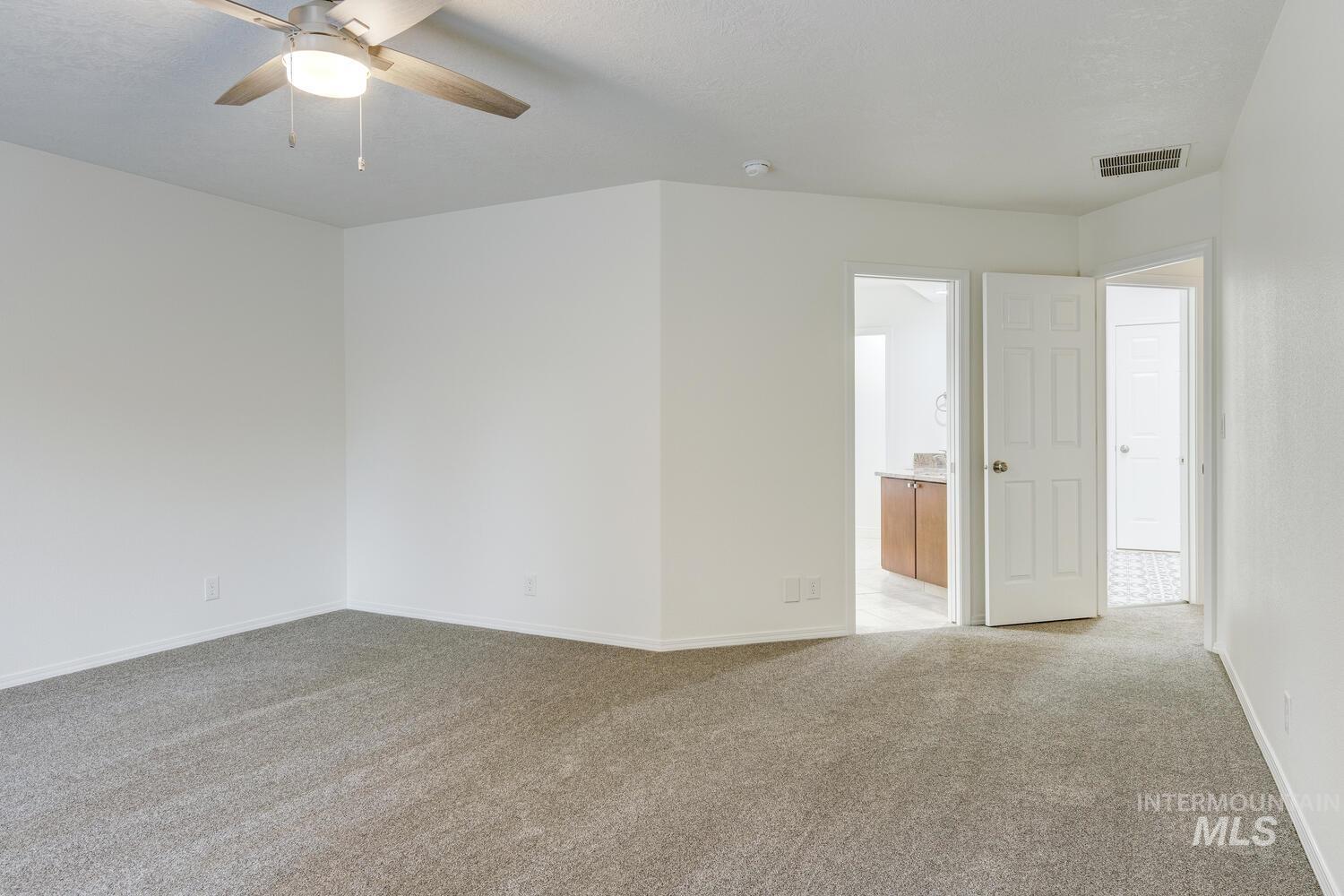 Empty room with light carpet and ceiling fan