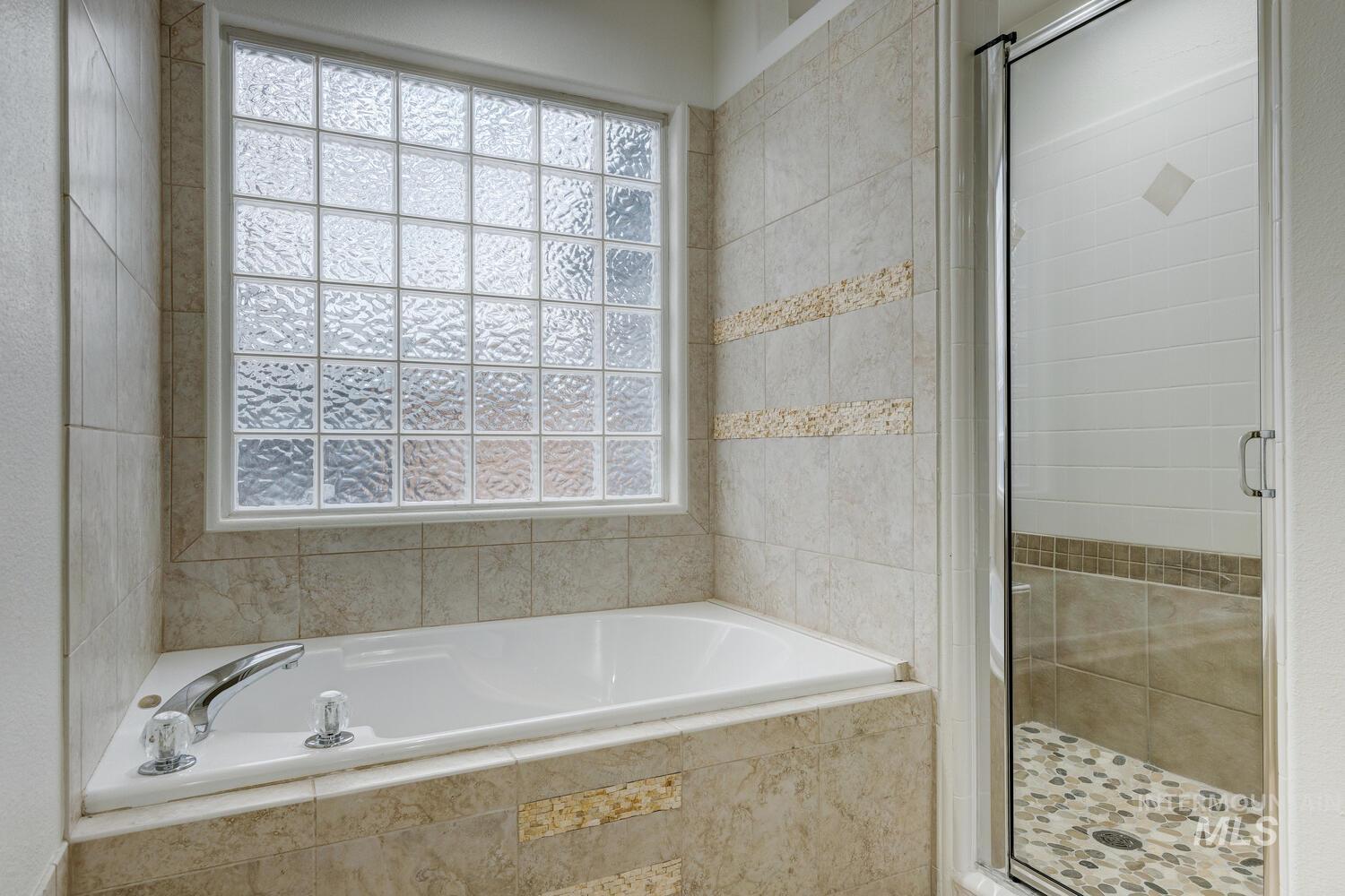Bathroom featuring a stall shower and a bath