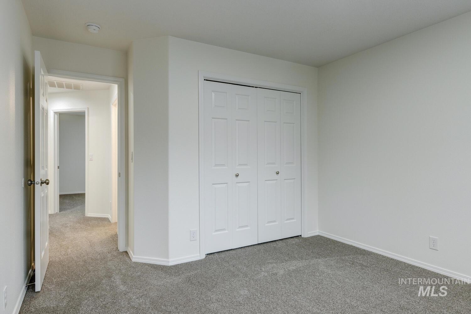 Unfurnished bedroom with carpet flooring and a closet