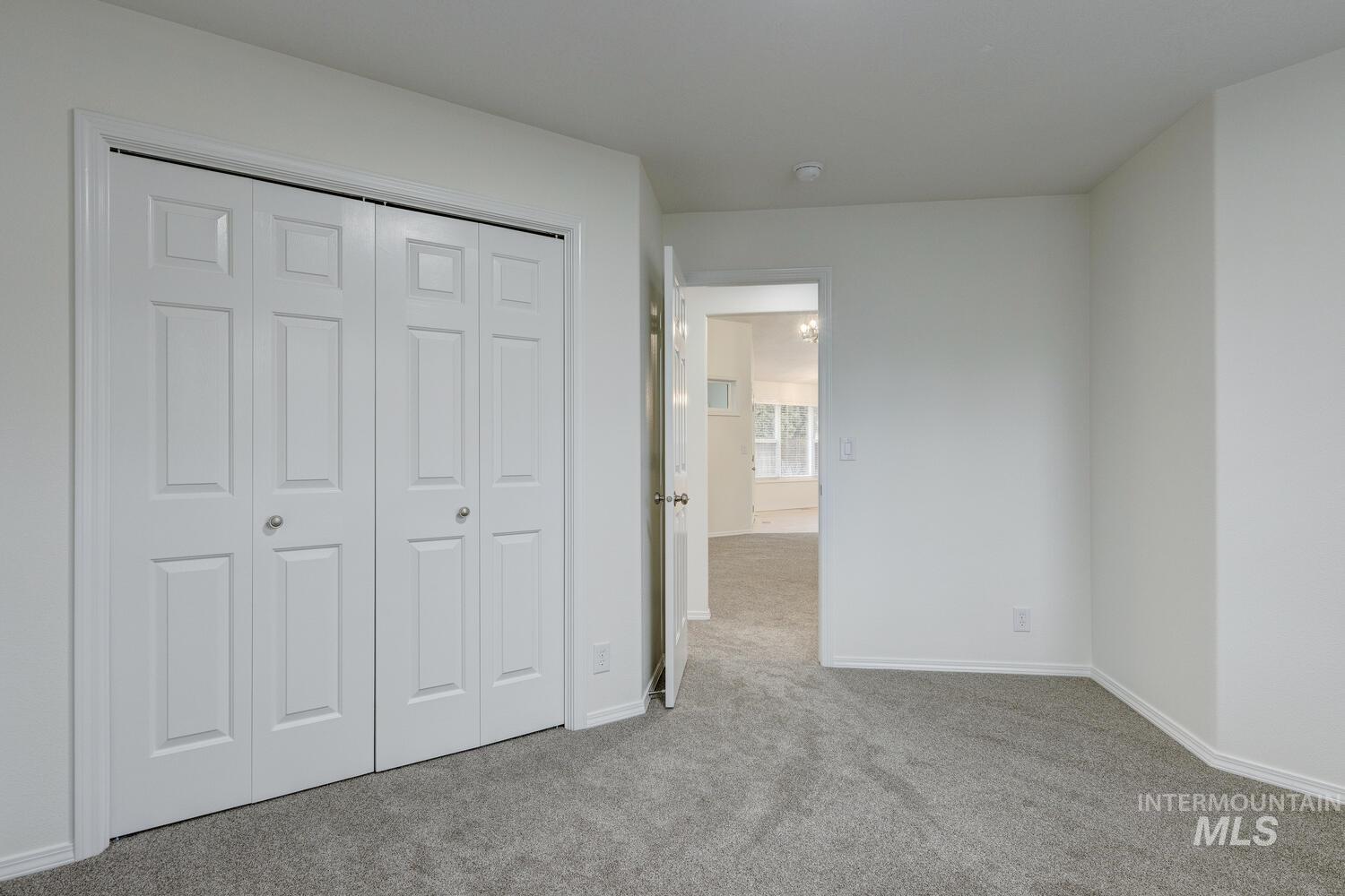 Unfurnished bedroom with light colored carpet and a closet