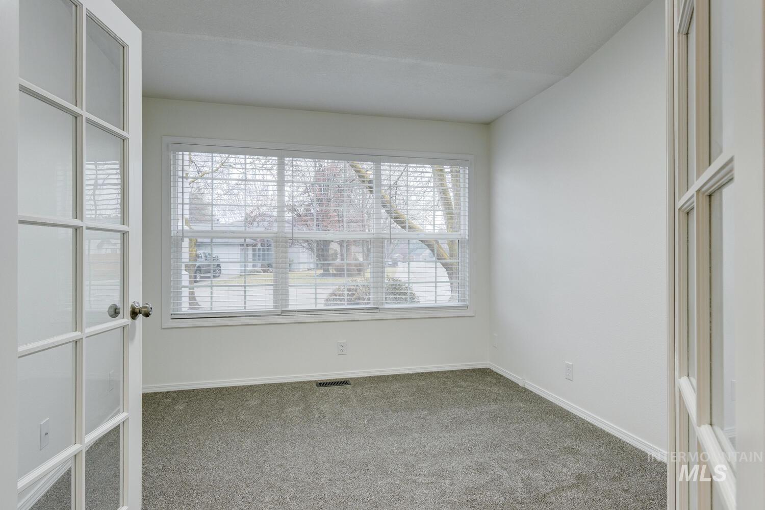 Carpeted empty room with baseboards
