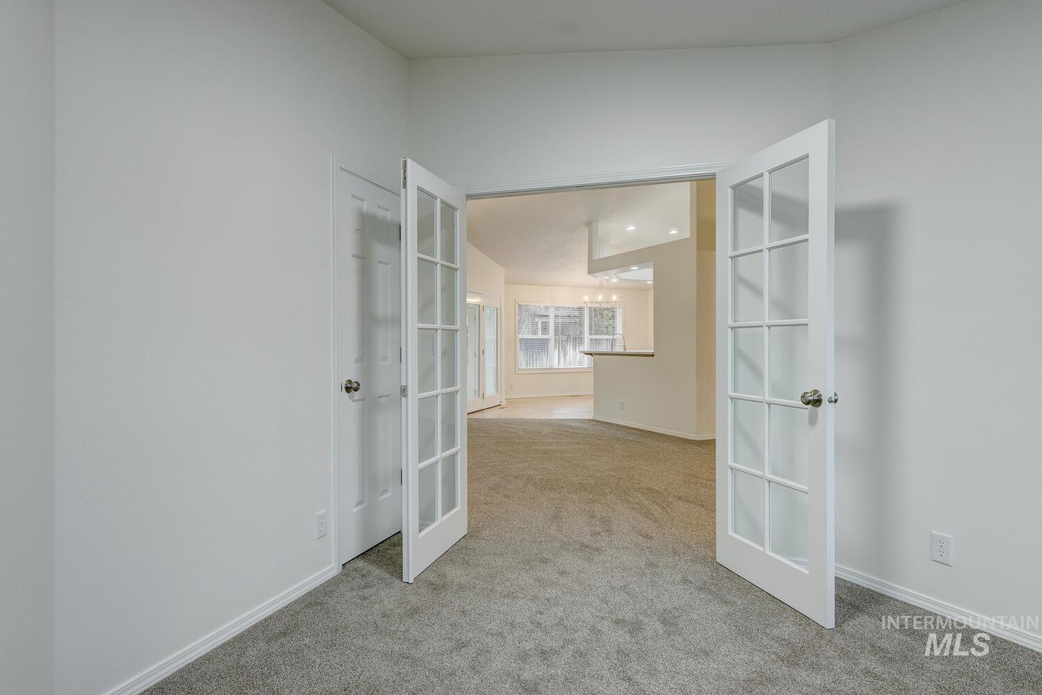 Unfurnished room featuring french doors and light carpet