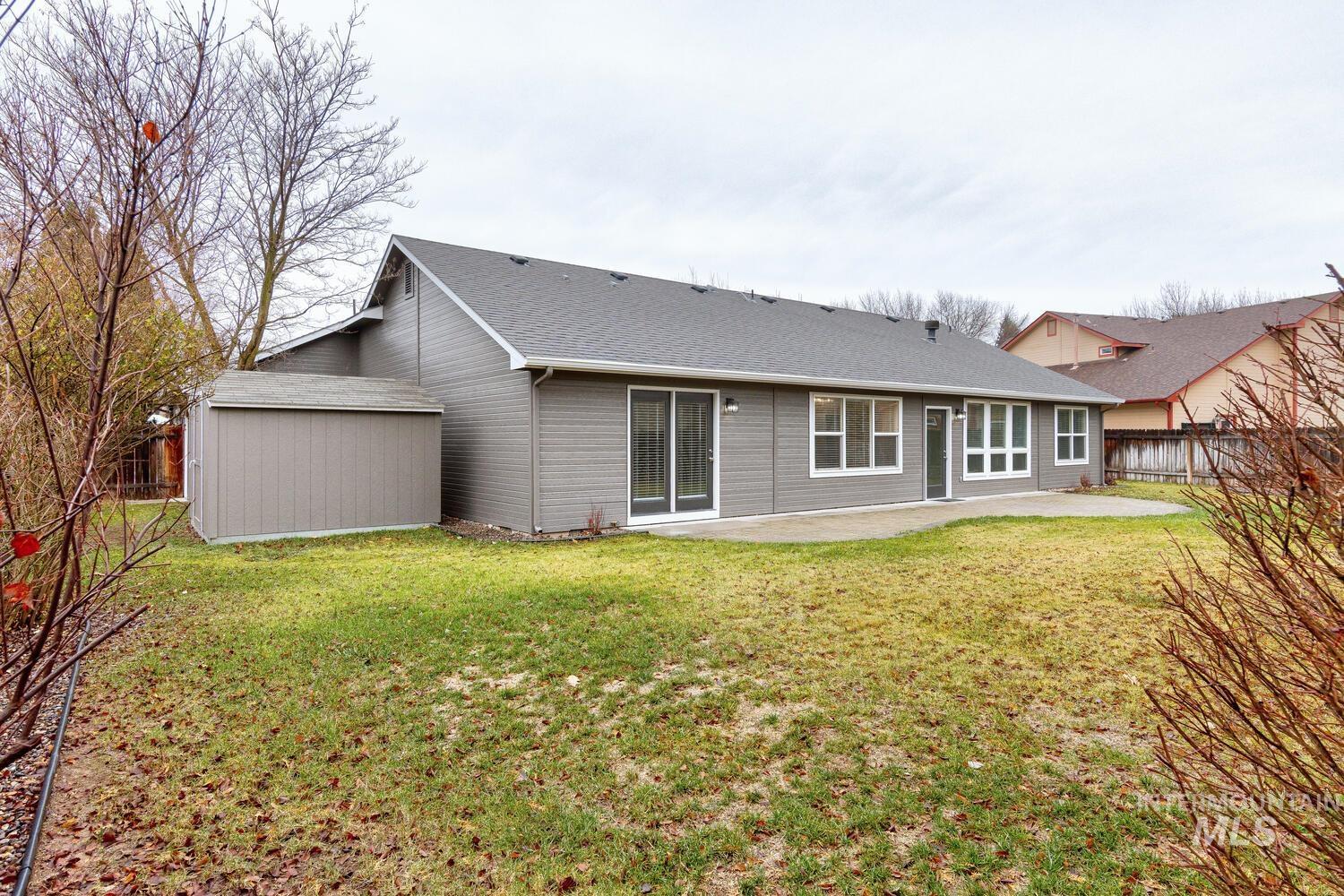 Rear view of house featuring a fenced backyard, a patio, and roof with shingles