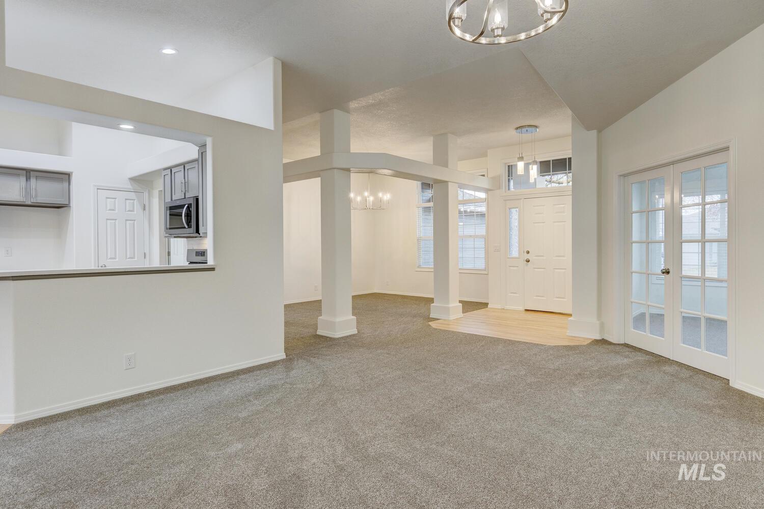 Entryway featuring a chandelier, light colored carpet, and french doors
