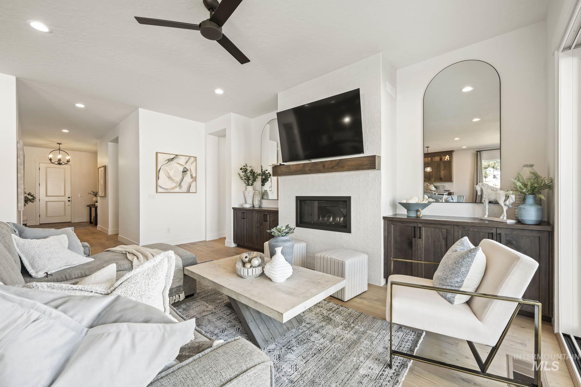 Living area with recessed lighting, wood finished floors, a glass covered fireplace, and ceiling fan