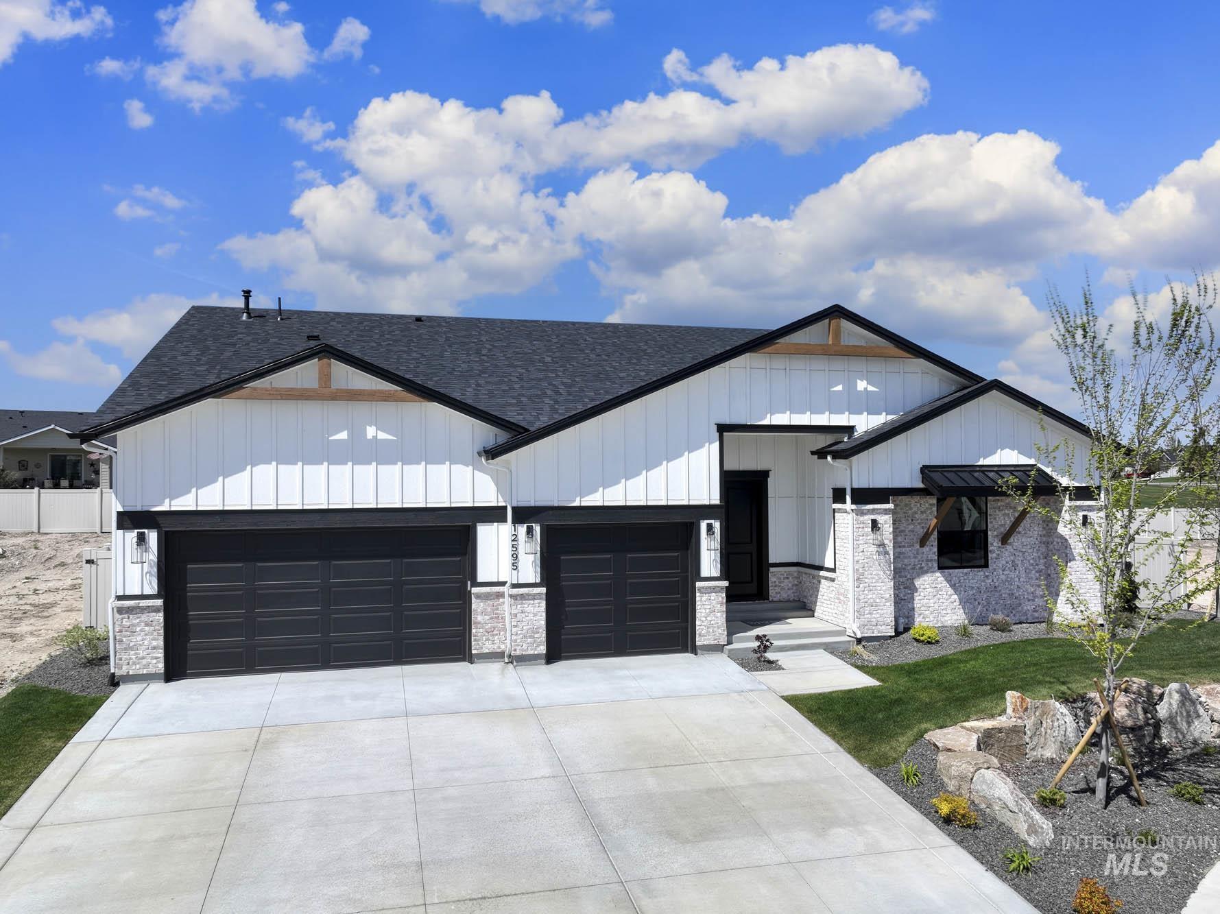 Modern farmhouse style home with board and batten siding, a garage, a shingled roof, driveway, and a front yard