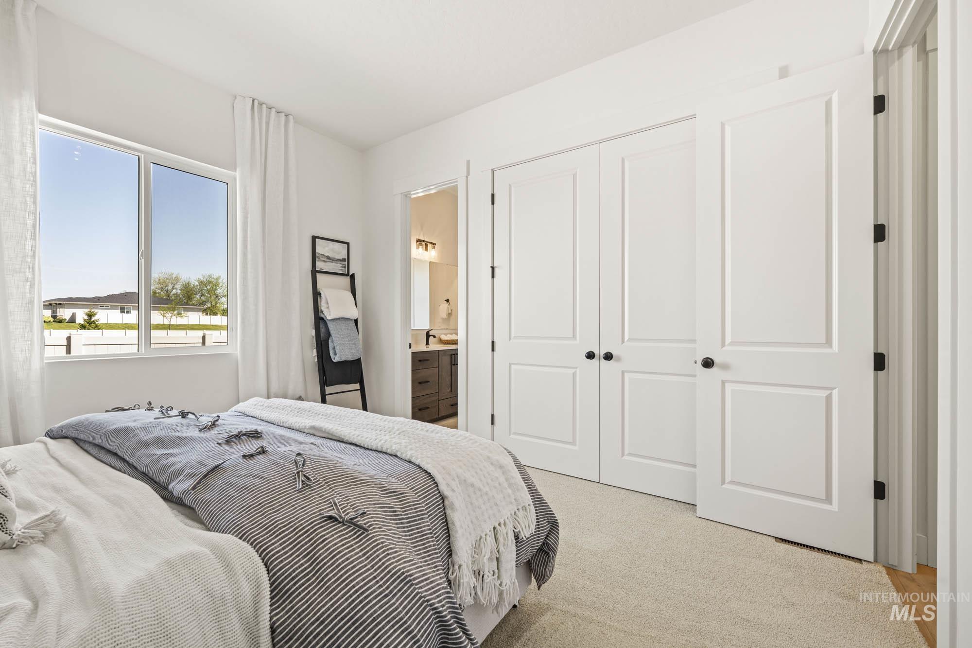 Bedroom with light colored carpet, a closet, and connected bathroom