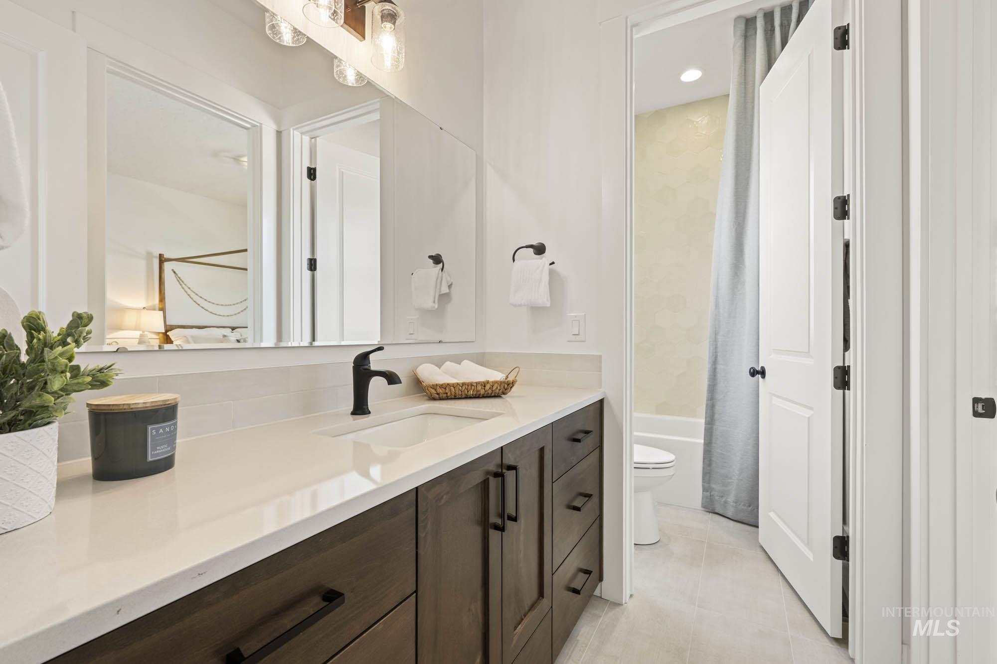 Full bath featuring vanity, shower / bath combo, and light tile patterned flooring