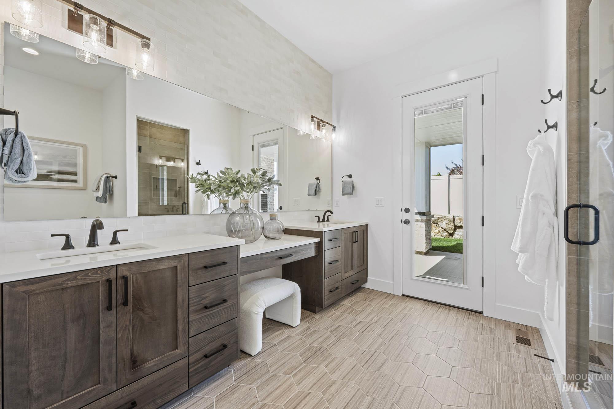 Bathroom featuring a shower stall and two vanities