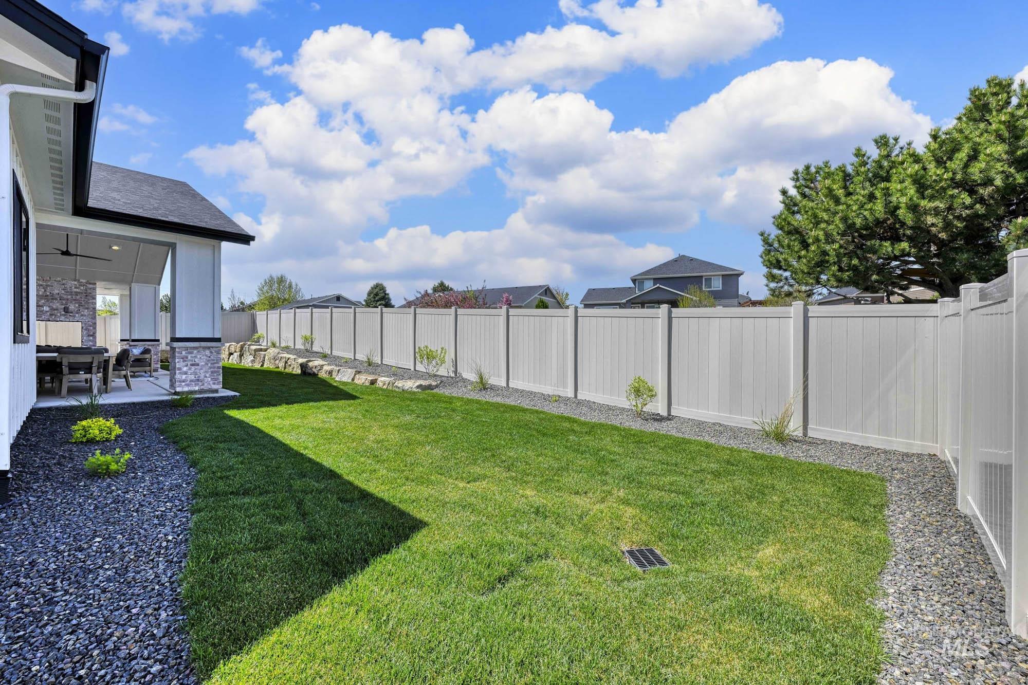 Fenced backyard with a sunroom, a patio, and ceiling fan