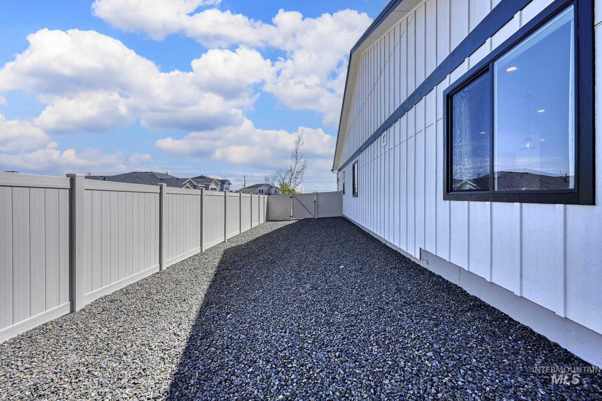 View of home's exterior with board and batten siding, a fenced backyard, and a gate