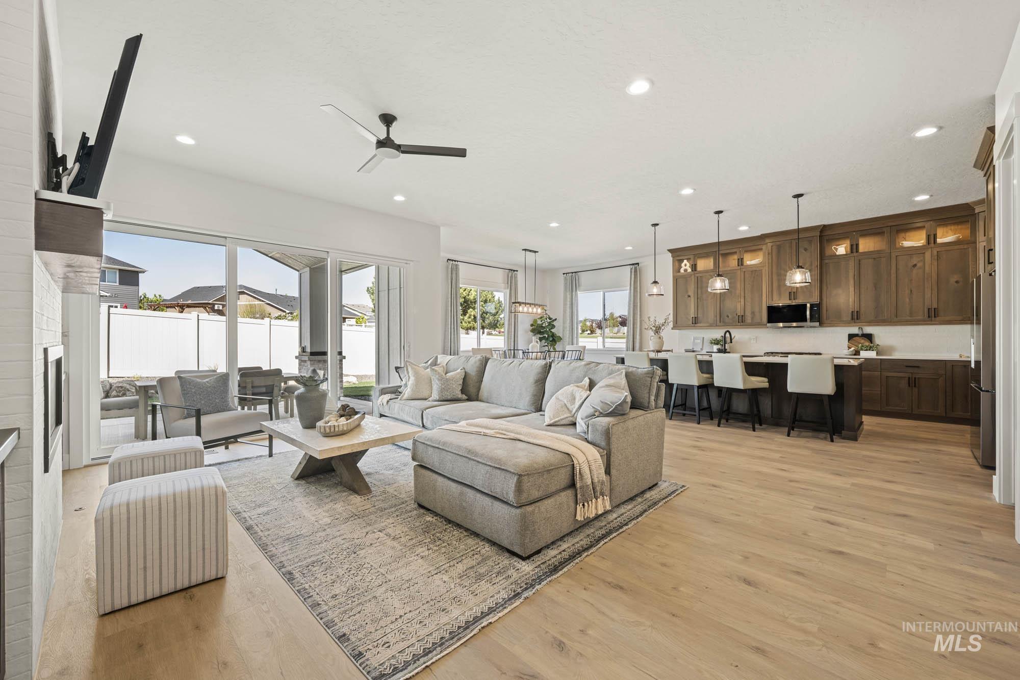 Living area featuring light wood-style flooring, healthy amount of natural light, ceiling fan, and recessed lighting