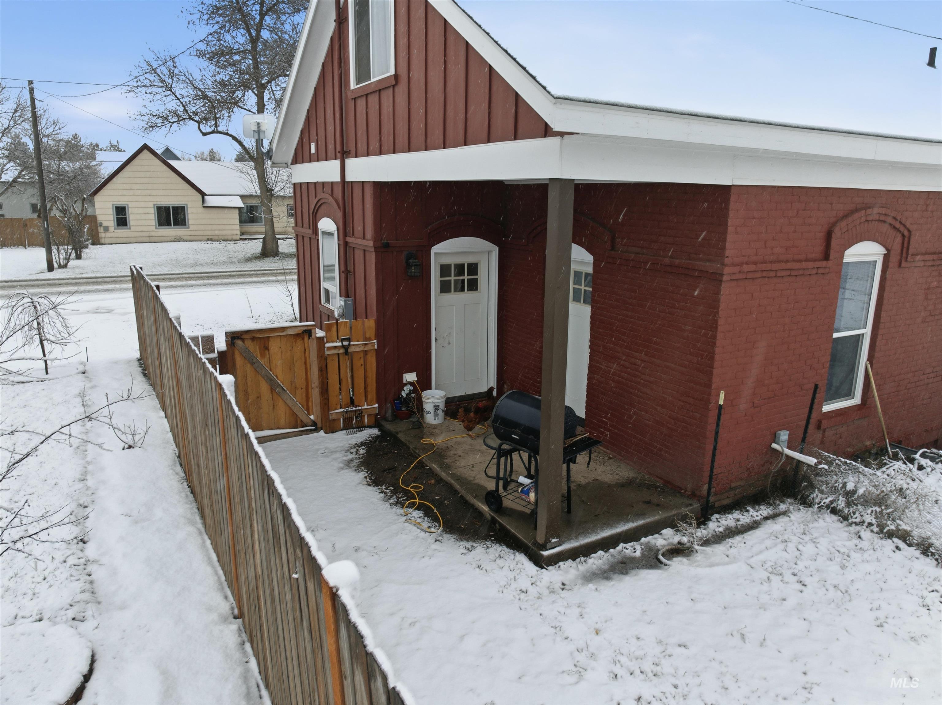 View of front facade with board and batten siding, brick siding, and a wooden deck