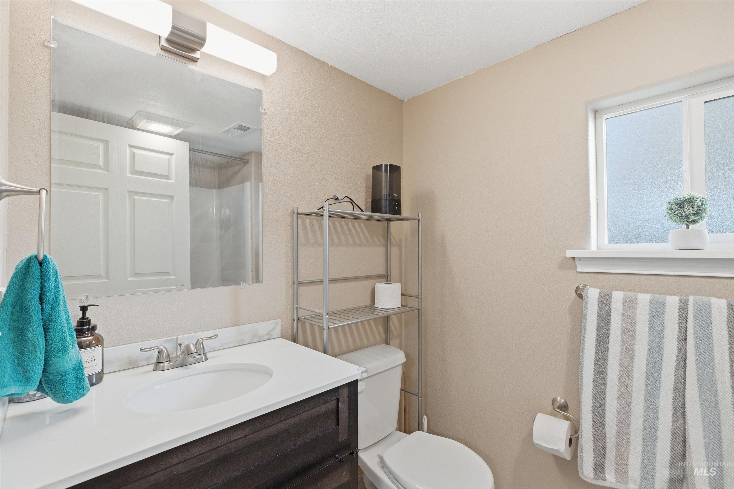 Bathroom with a shower with curtain and vanity