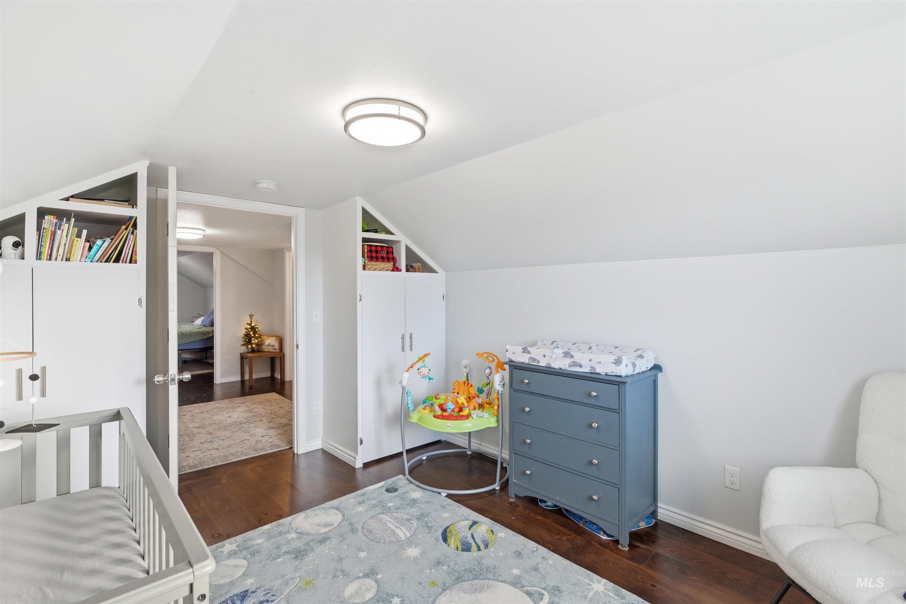 Bedroom featuring vaulted ceiling and dark wood finished floors