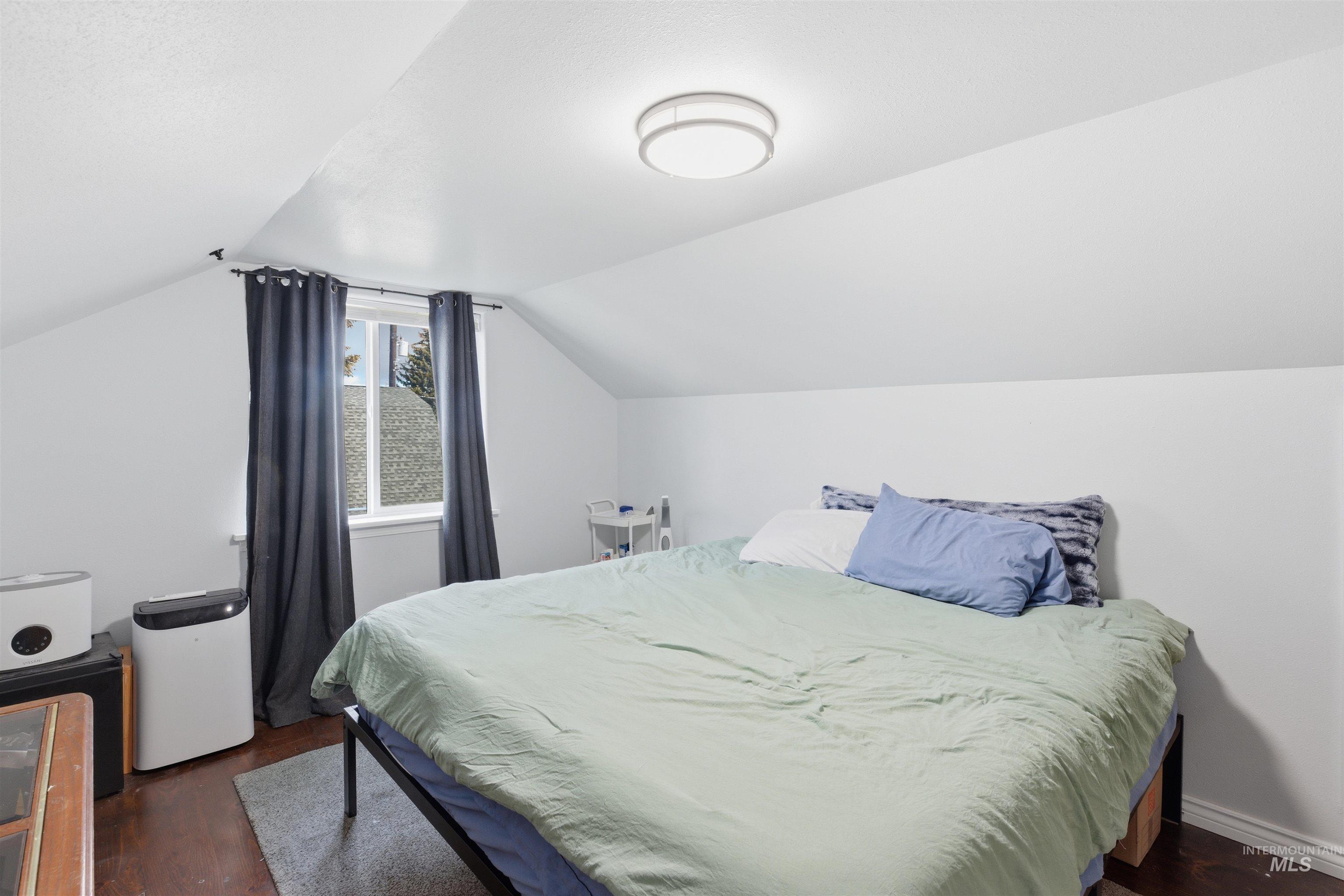 Bedroom featuring vaulted ceiling and dark wood finished floors
