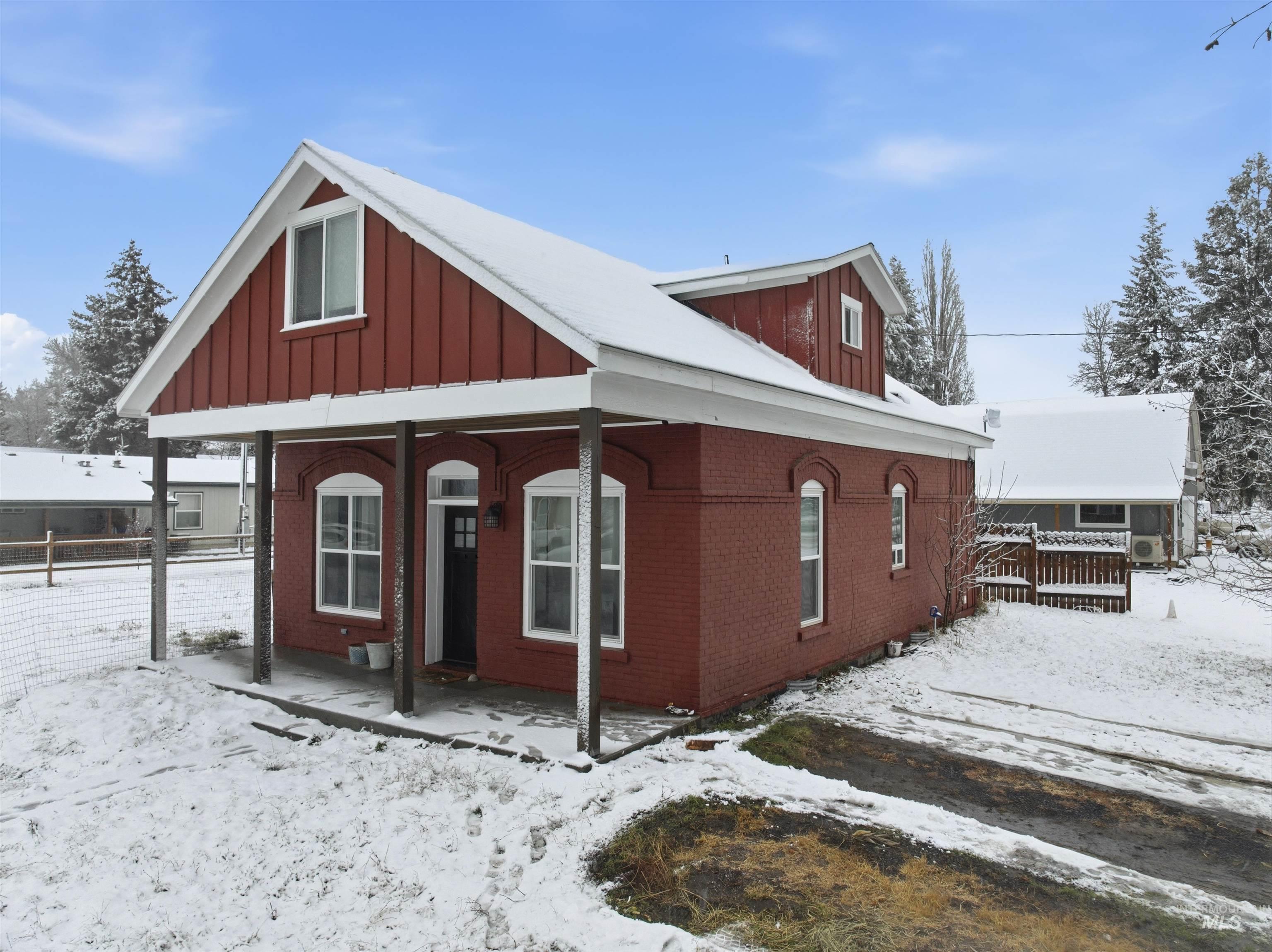 View of front of house featuring a porch, board and batten siding, and brick siding
