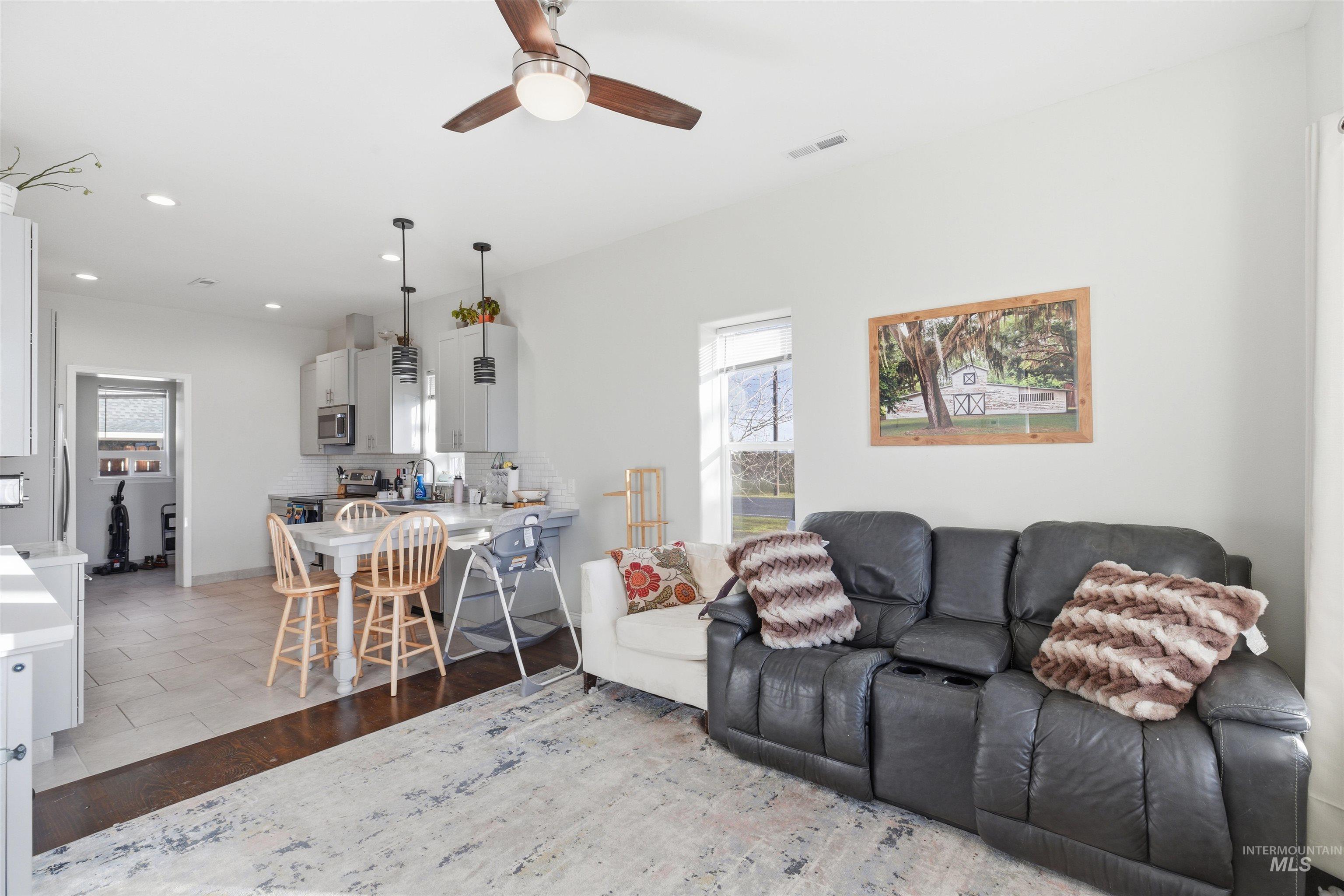 Living room featuring recessed lighting, a ceiling fan, and light wood-type flooring