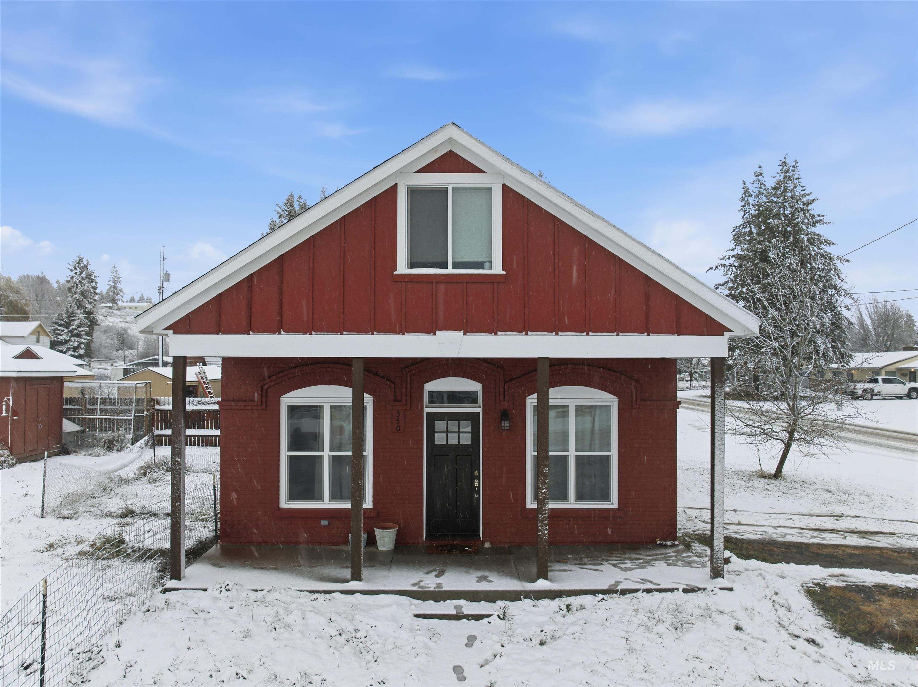 View of front facade with a porch and board and batten siding