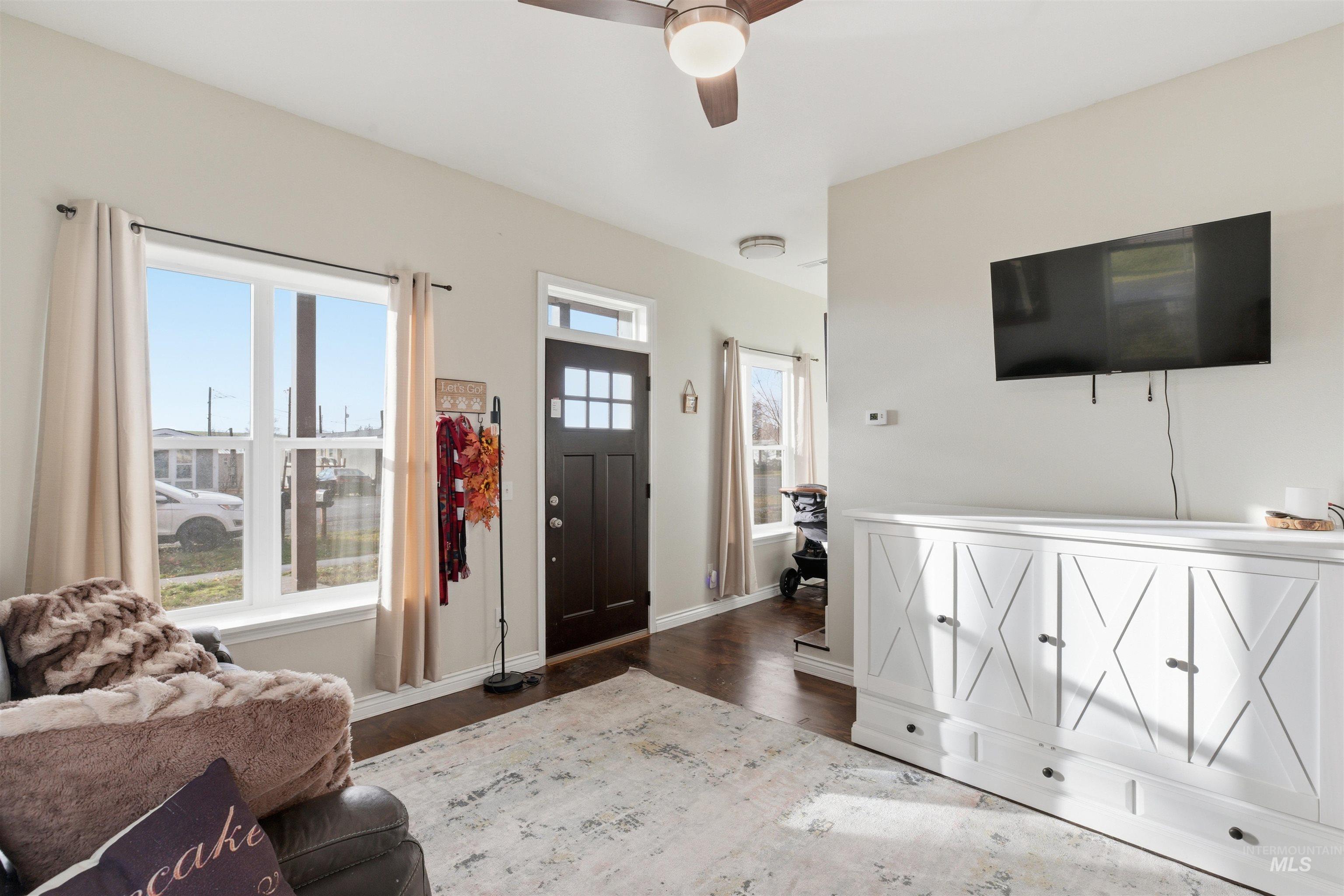 Foyer entrance featuring dark wood-type flooring and a ceiling fan