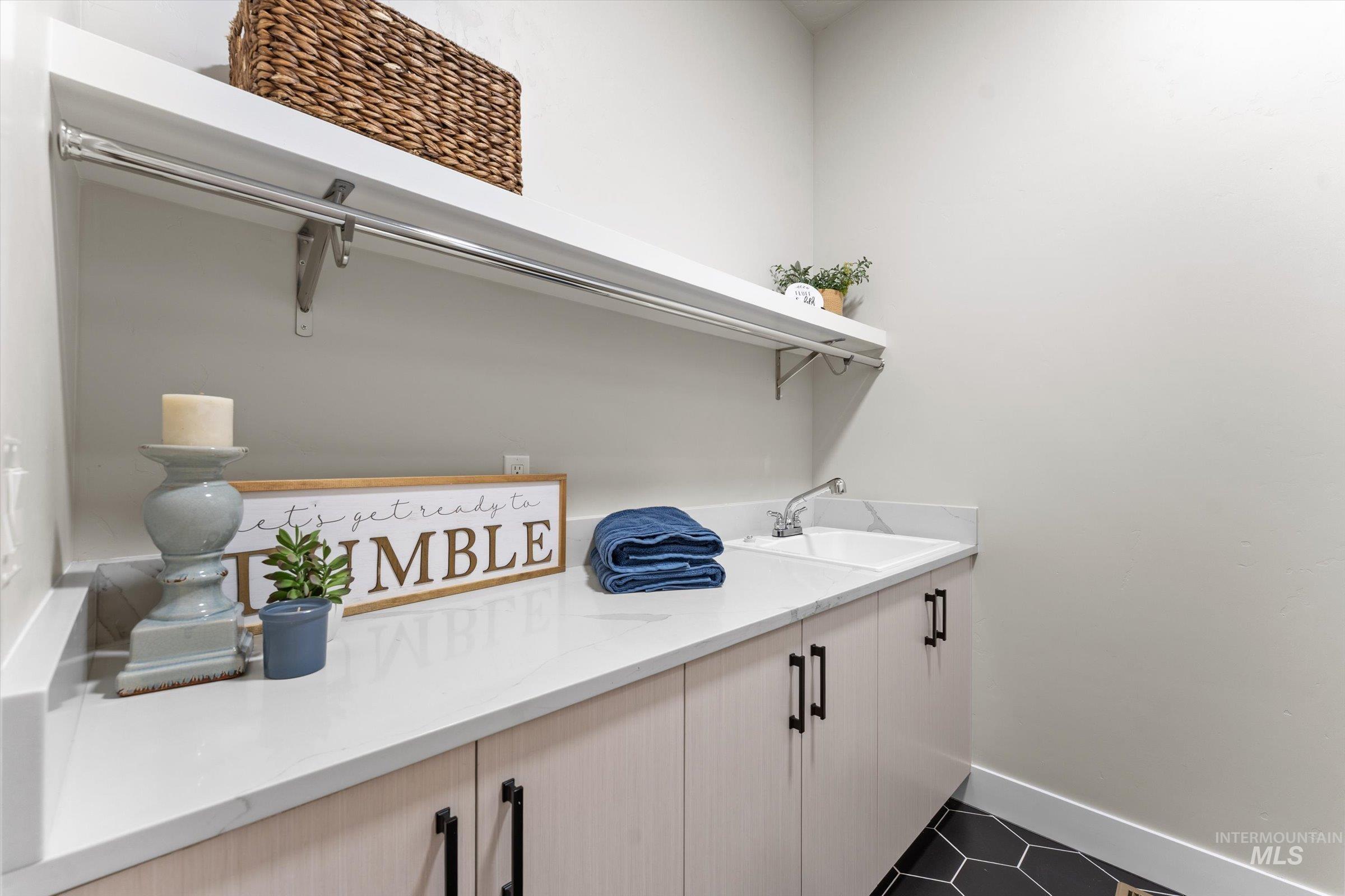 Large laundry room with shelves and sink