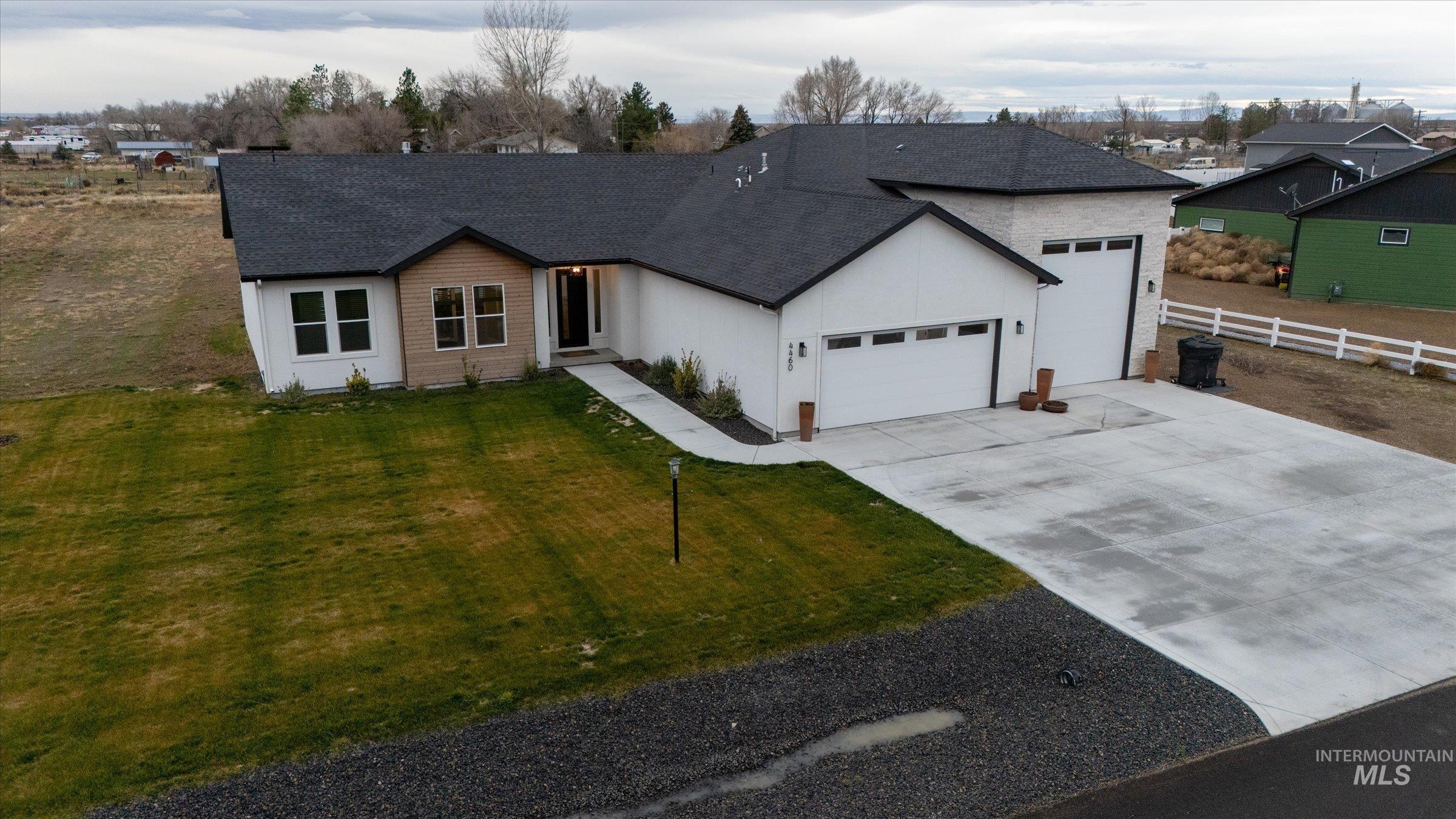 Ranch-style home with driveway, an attached garage, and a shingled roof