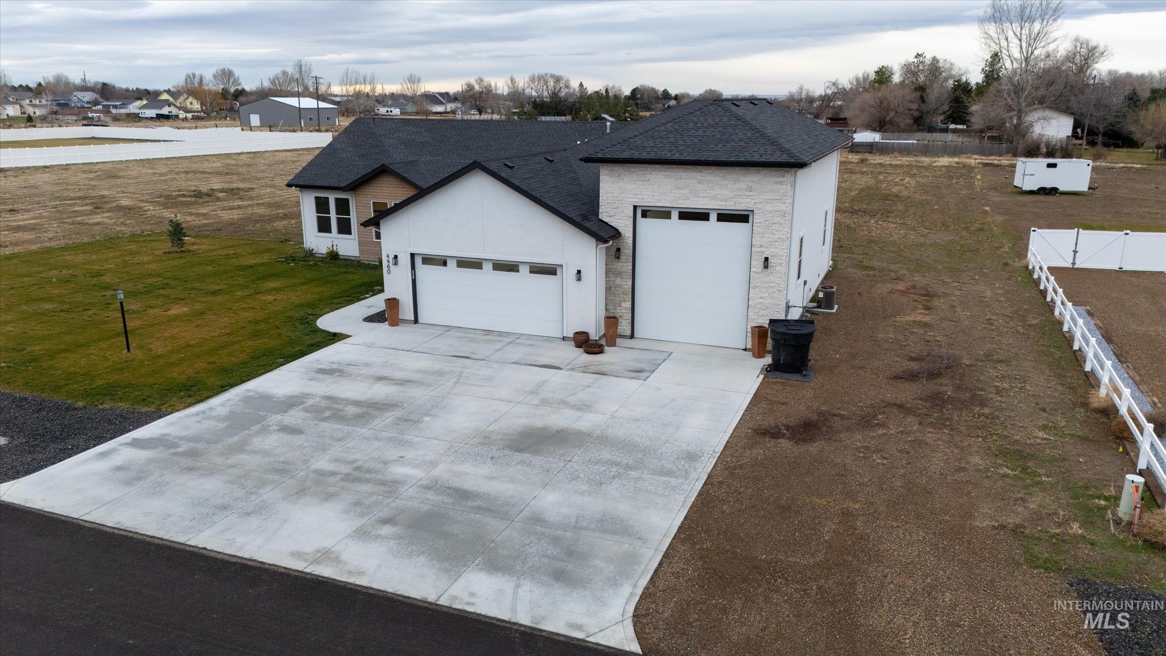 View of front of home with driveway, a garage, stucco siding, and a shingled roof