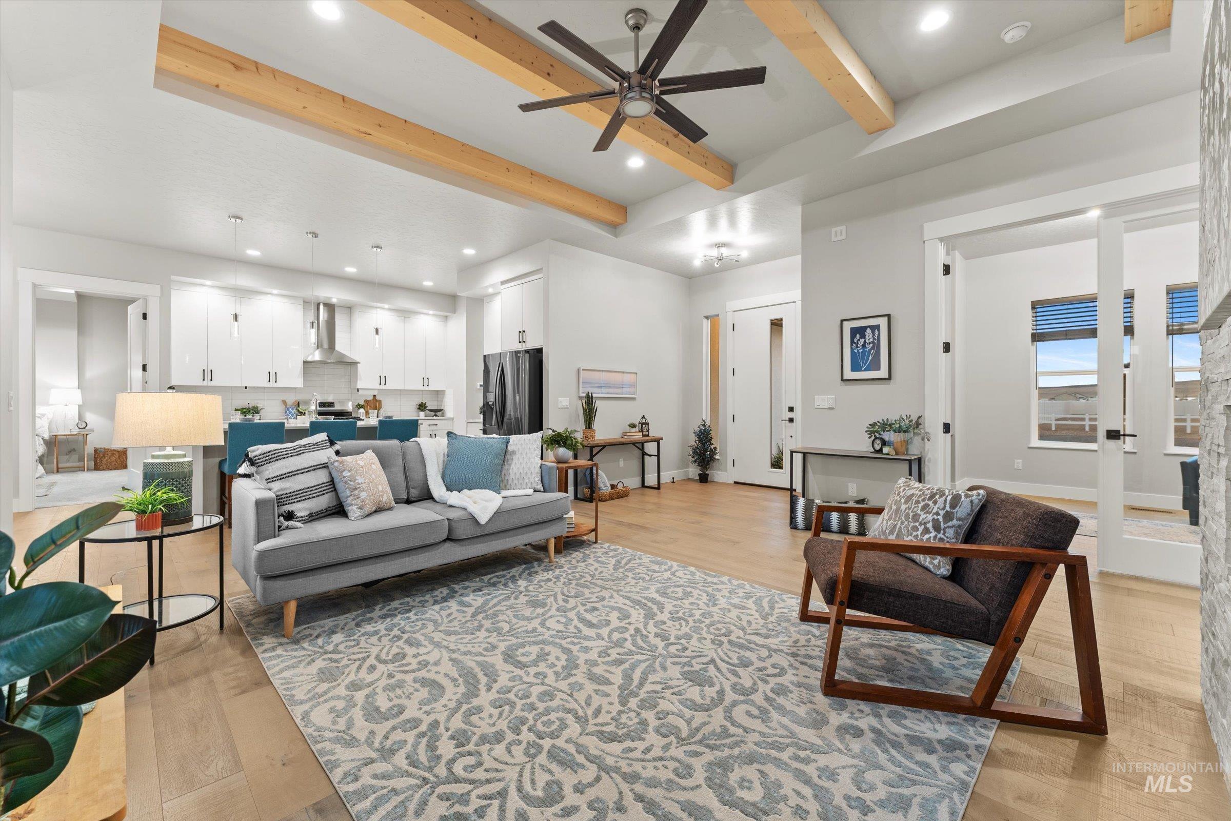 Living area with beamed ceiling, a ceiling fan, light wood-style flooring, and recessed lighting