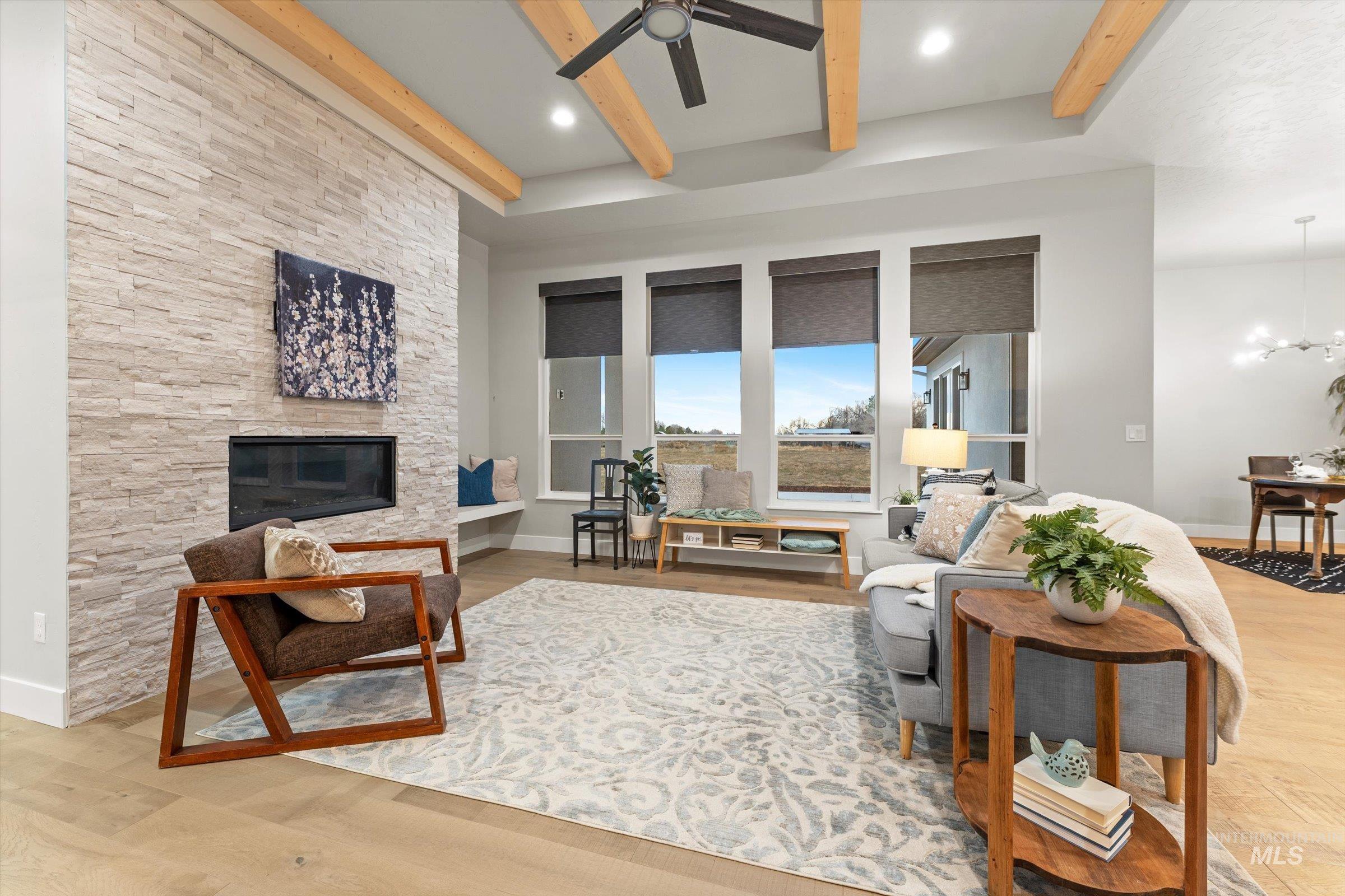 Living area featuring light wood-type flooring, beamed ceiling, a gas fireplace, and recessed lighting