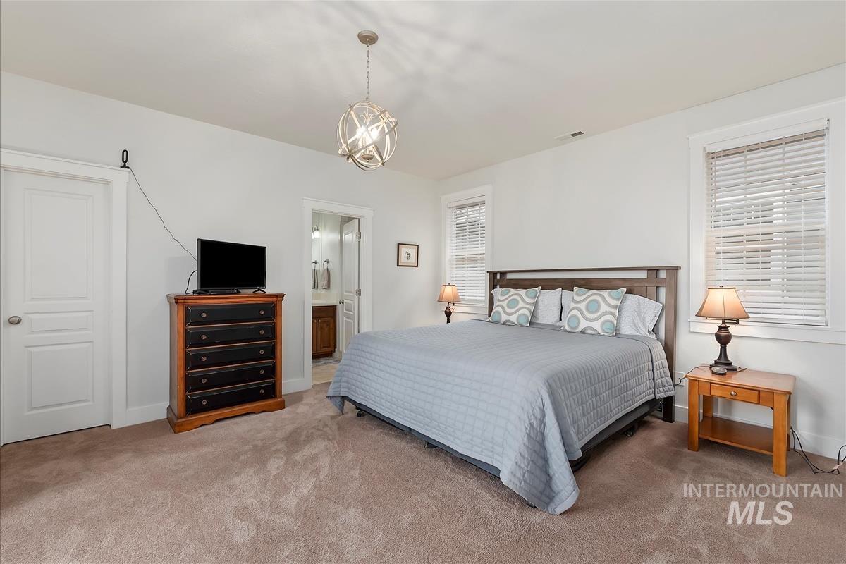 Bedroom with ensuite bathroom and carpet flooring