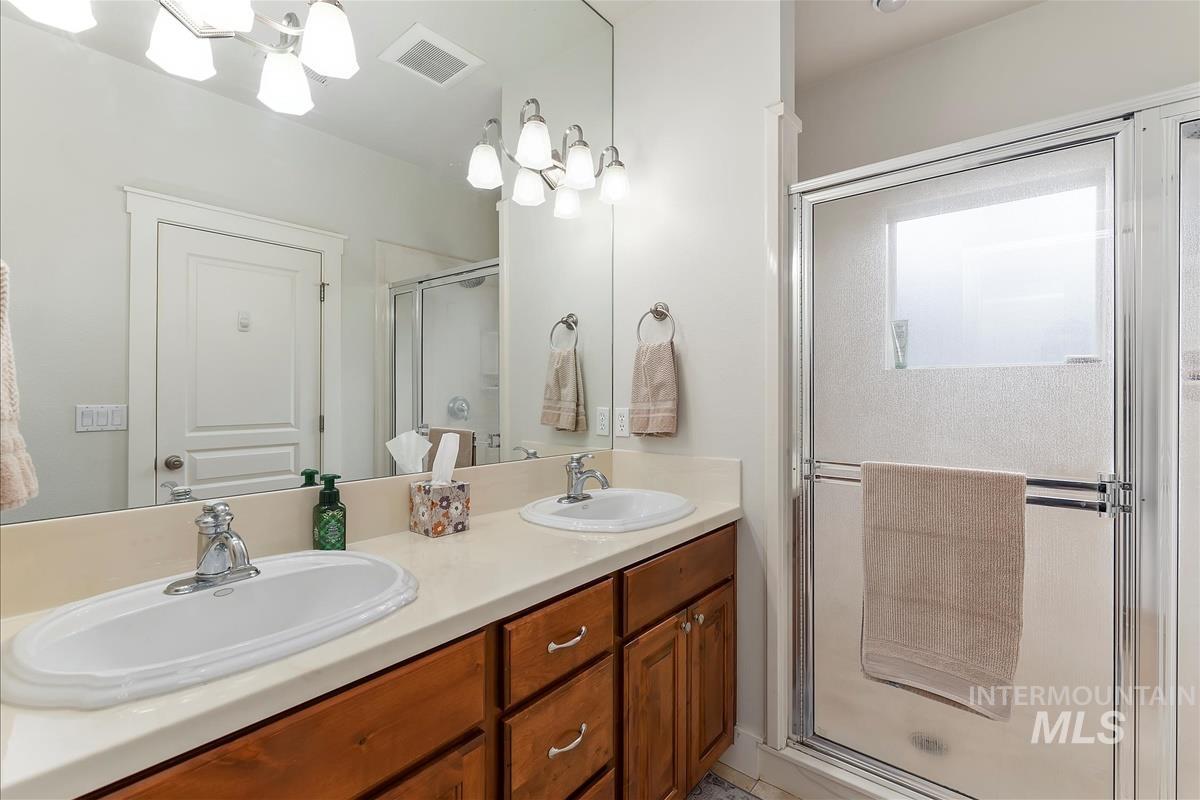 Bathroom with a shower stall and double vanity