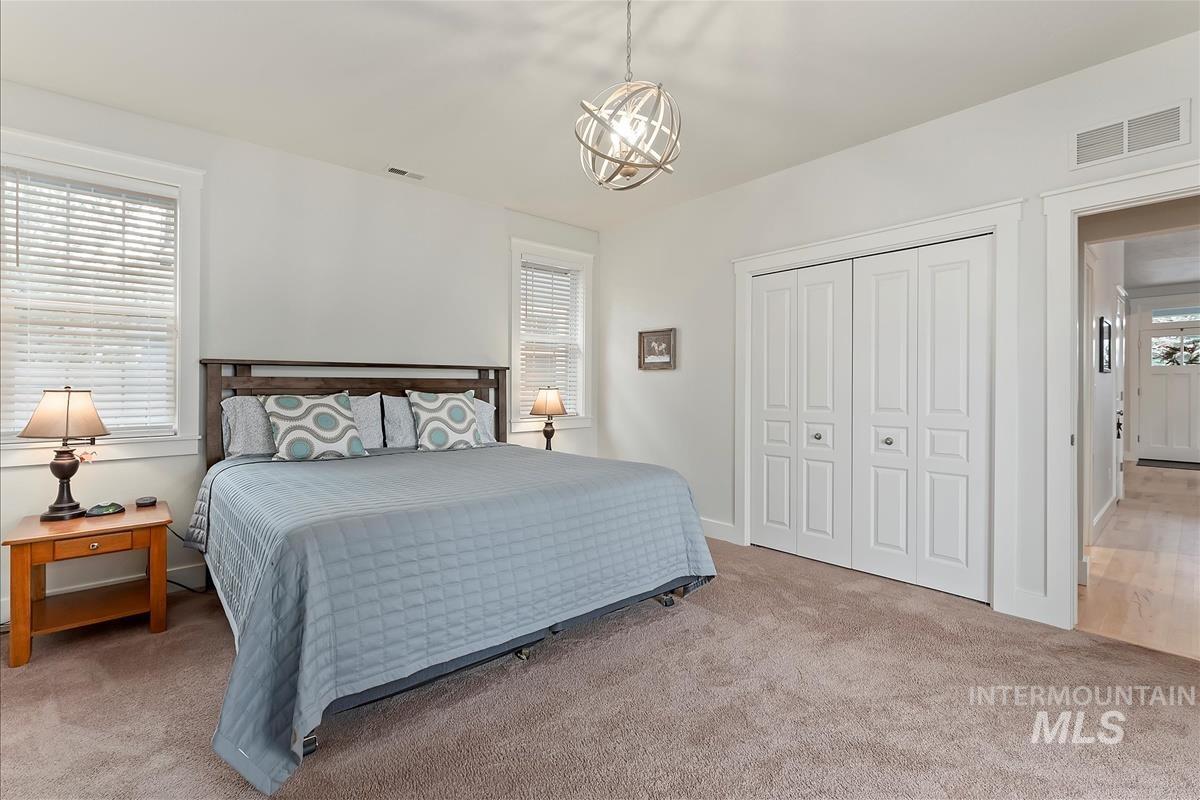 Bedroom with light colored carpet and a closet