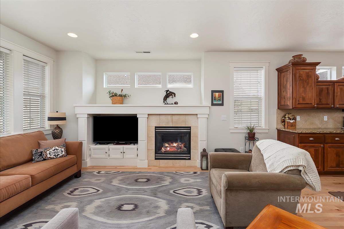 Living area featuring a tile fireplace, light wood finished floors, and recessed lighting