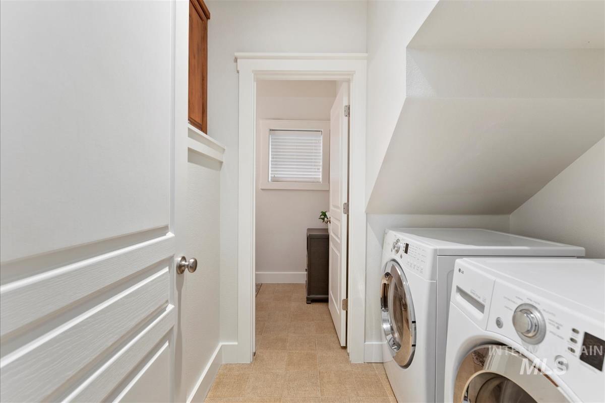 Washroom with baseboards and washing machine and clothes dryer