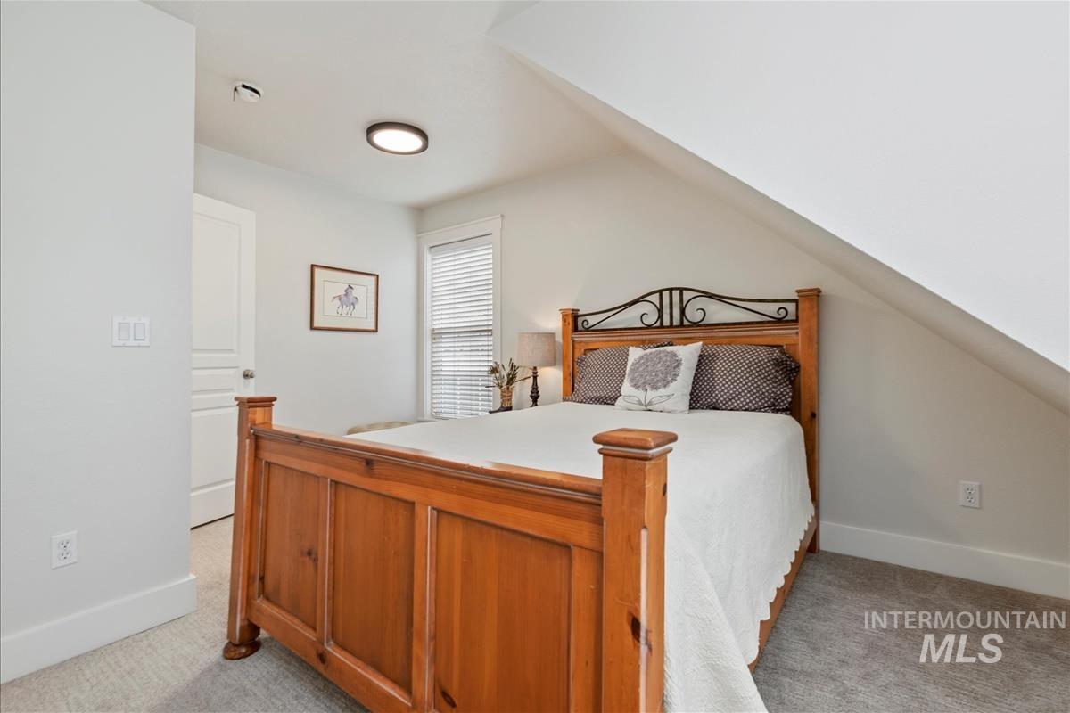 Bedroom with light colored carpet and baseboards