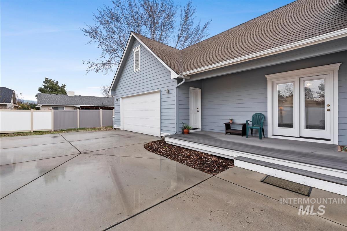 View of home's exterior featuring driveway, roof with shingles, and a deck