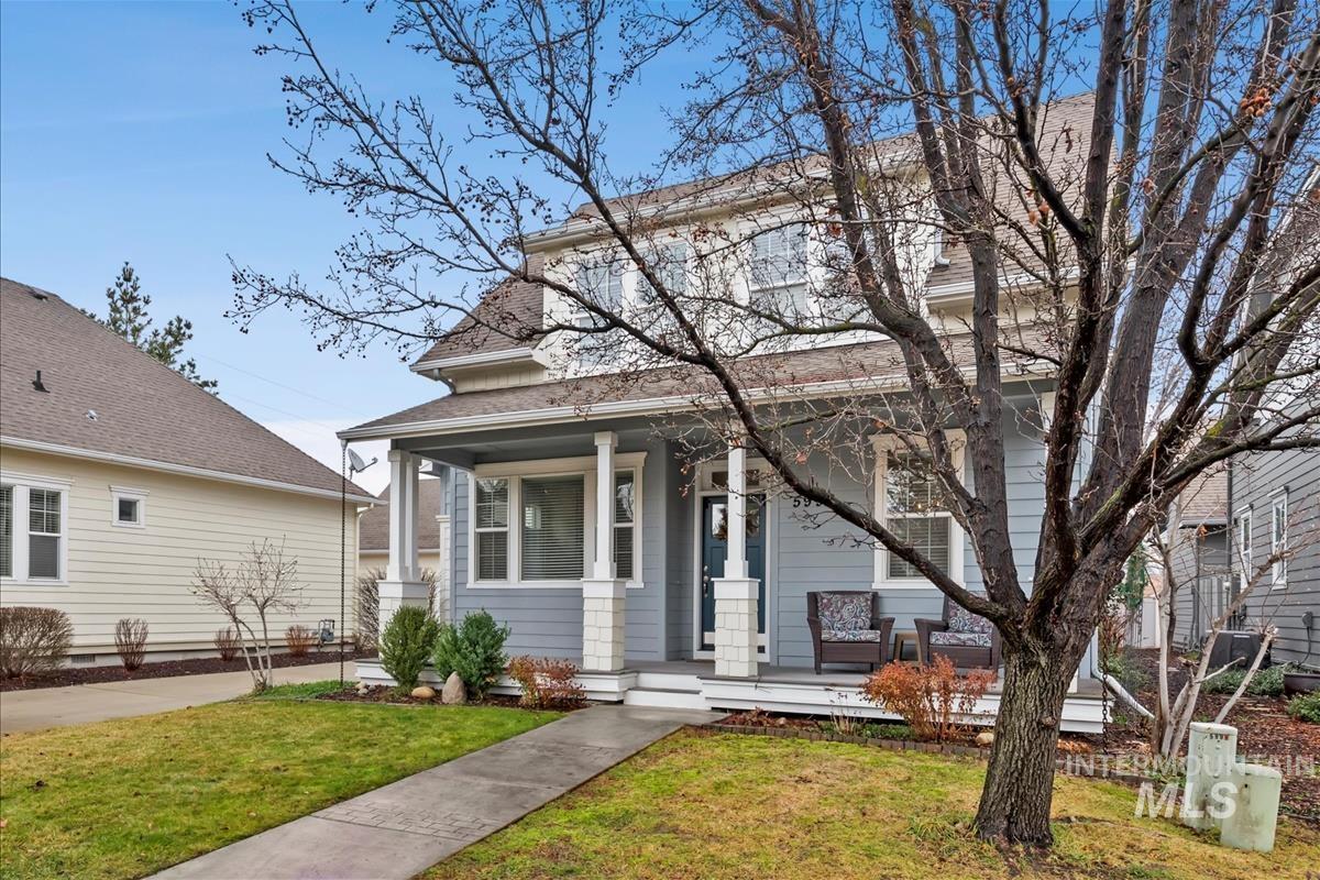 View of front of home with a porch, a front yard, and a shingled roof