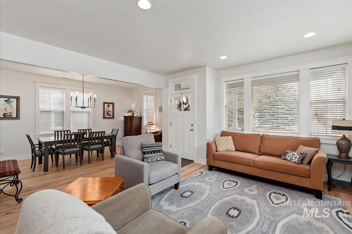 Living area with light wood finished floors, recessed lighting, and a chandelier