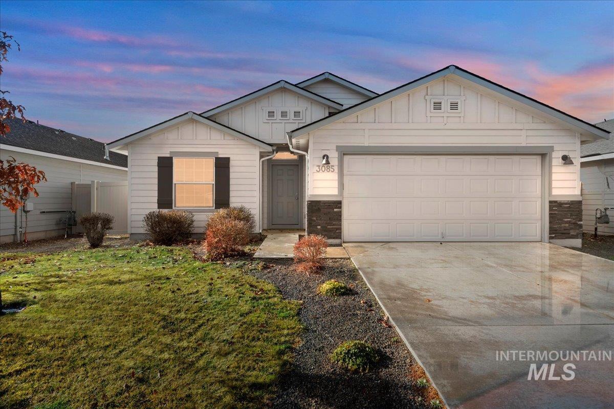Ranch-style home with board and batten siding, concrete driveway, stone siding, and a garage