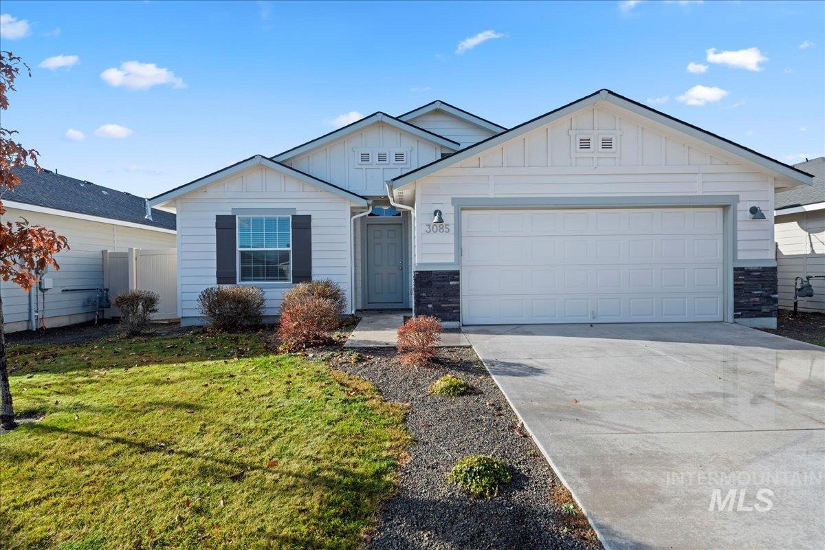 Ranch-style home with board and batten siding, stone siding, concrete driveway, and an attached garage
