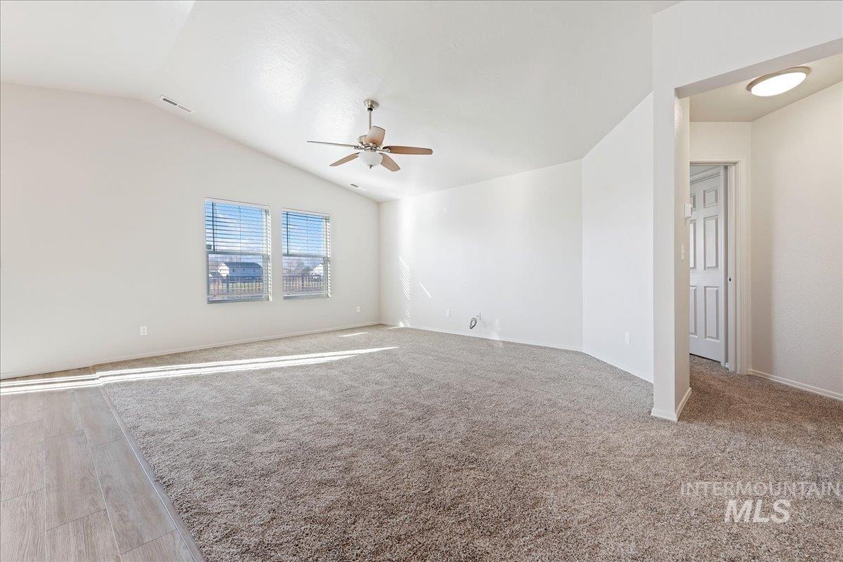 Unfurnished room featuring lofted ceiling and a ceiling fan